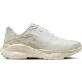 A light beige and white Nike Women’s Structure Plus ESS Running Shoe featuring a mesh upper, cream-colored sole, and signature swoosh logo on the side. Designed for stability, this shoe offers double-stacked cushioning for enhanced support, with ZOOMX and reactX technology text embossed on the sole. The colorway is White / Sail / Sea Glass / White.
