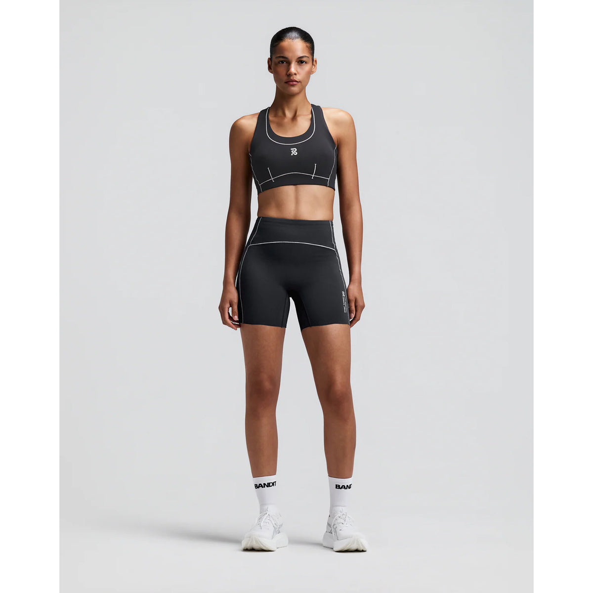 Women's Bandit Vanisher Pop Stitch Arco Run Bra Anthracite front full body view on female runner showing Vanisher compression with Pop Stitch detail and three-pocket system for running and training