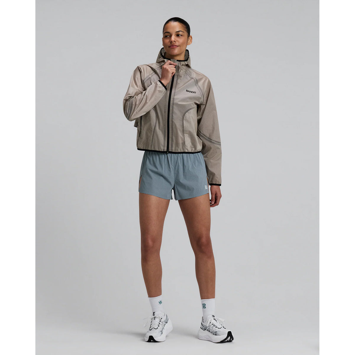 Women's Bandit VeloRip Ultralight Windproof Jacket Oatmeal full body front view on female runner showing lightweight windproof construction with 2 zipper stash pockets