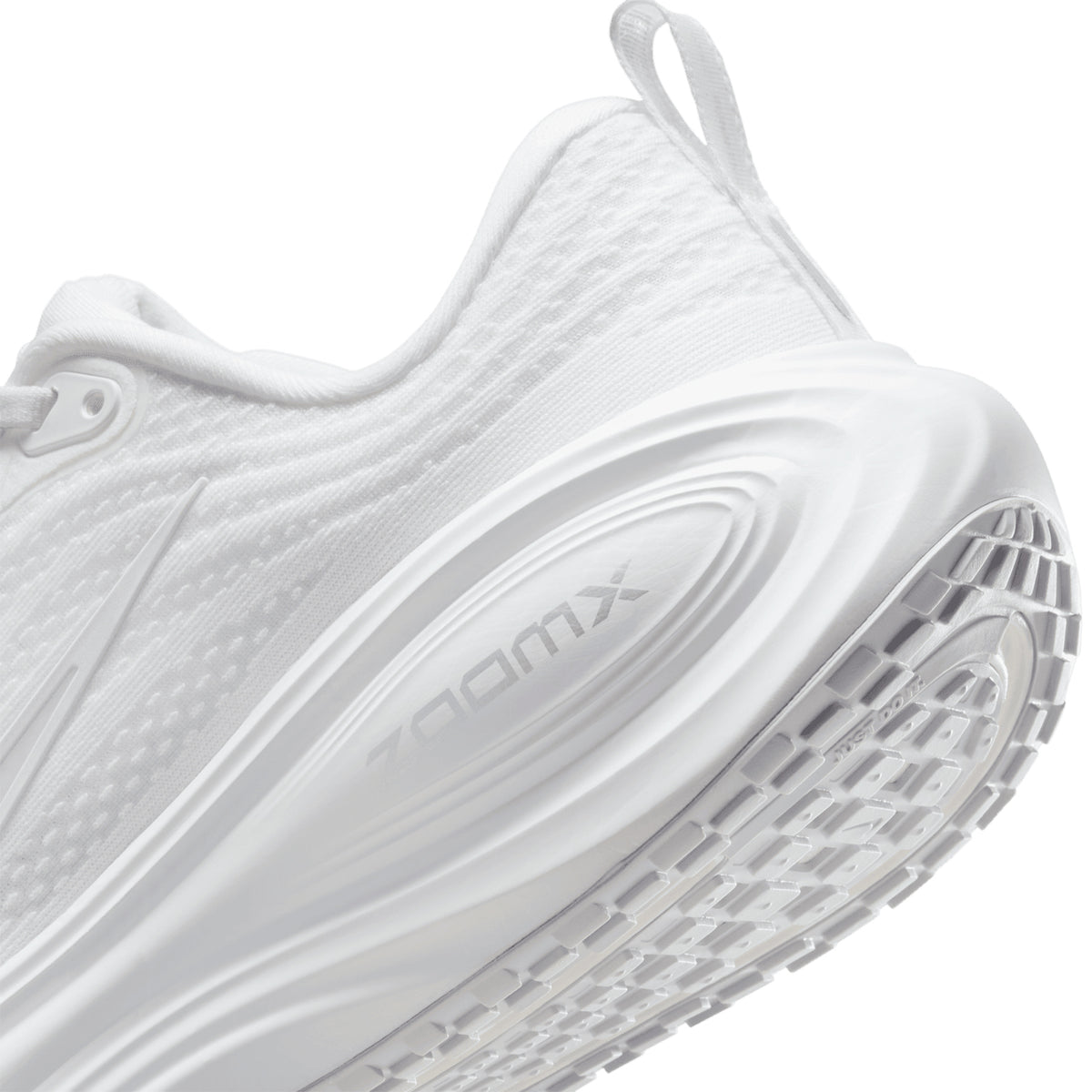 Nike Vomero Plus women's running shoe in White / Photon Dust / Metallic Silver / Summit White — angled side view showing white engineered mesh upper, responsive cushioning design and photon dust cushioning midsole stack