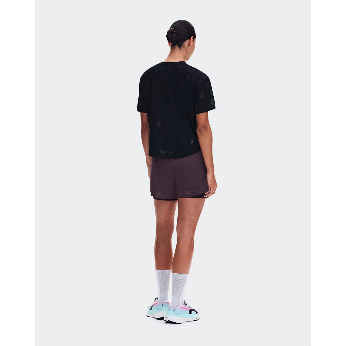 Women's On Zero-T Breathe Black back full body view on female runner showing reflective detailing with minimalist jacquard construction and On DryTec quick-drying fabric for training runs