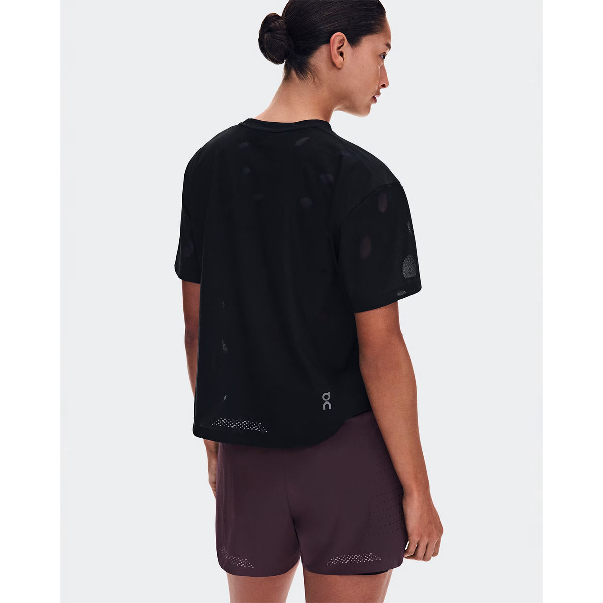 Women's On Zero-T Breathe Black back view on female runner showing reflective detailing with functional jacquard fabric and On DryTec moisture-wicking construction