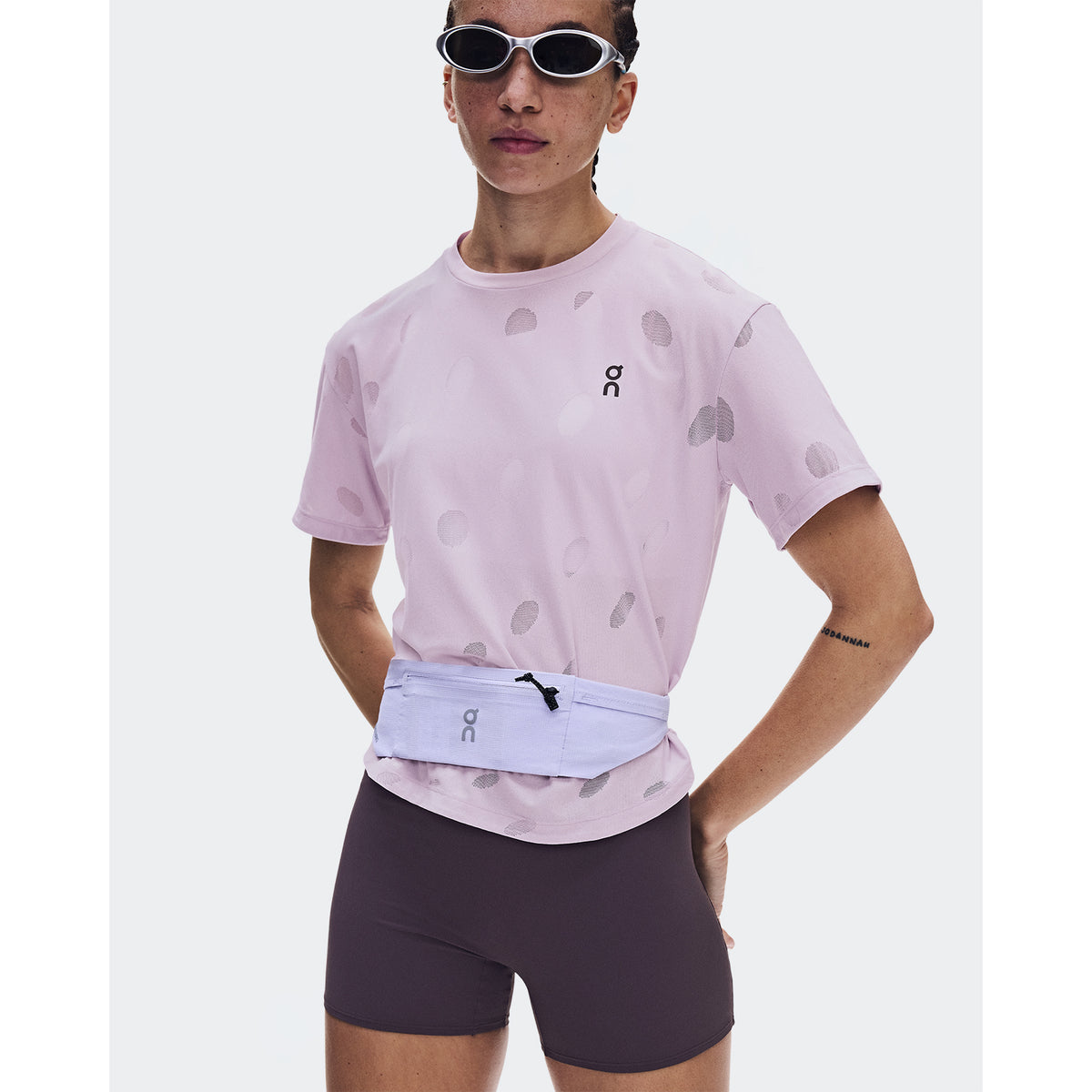 Women's On Zero-T Breathe Foxglove front view on female runner wearing sunglasses and hip bag showing ultralight functional jacquard construction with On DryTec breathable fabric for versatile training and lifestyle wear