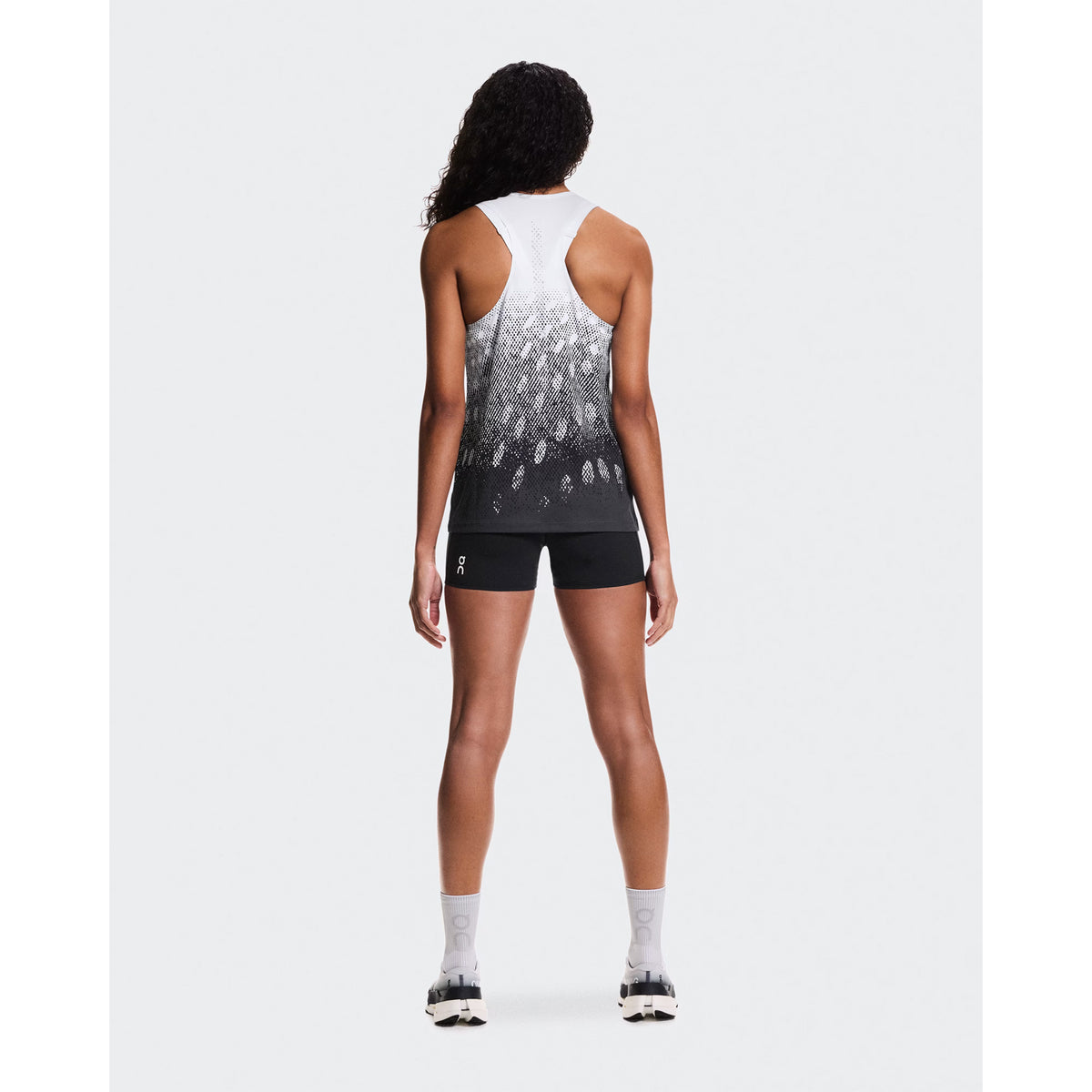 Women's On Zero Singlet White Black Grey full body back view on female runner showing athletic racer-back styling and reflective detail for visibility