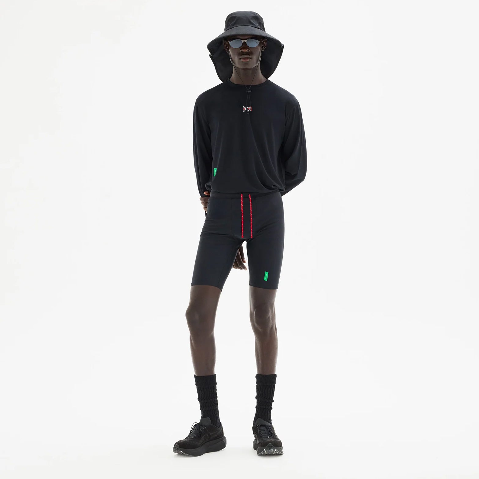 District Vision 9 Inch Recycled Half Tights Black full body view on male runner showing four-way stretch with side phone pocket featuring interior dividers and discrete waistband key pocket