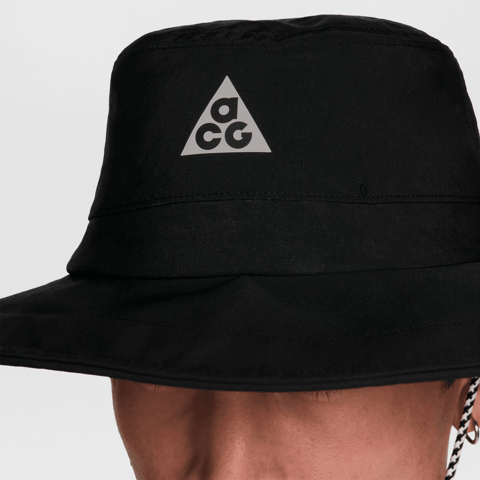 Nike ACG Apex bucket hat in Black — closeup product shot showing black lightweight taffeta fabric detail, water-repellent finish and crisp construction of wraparound brim