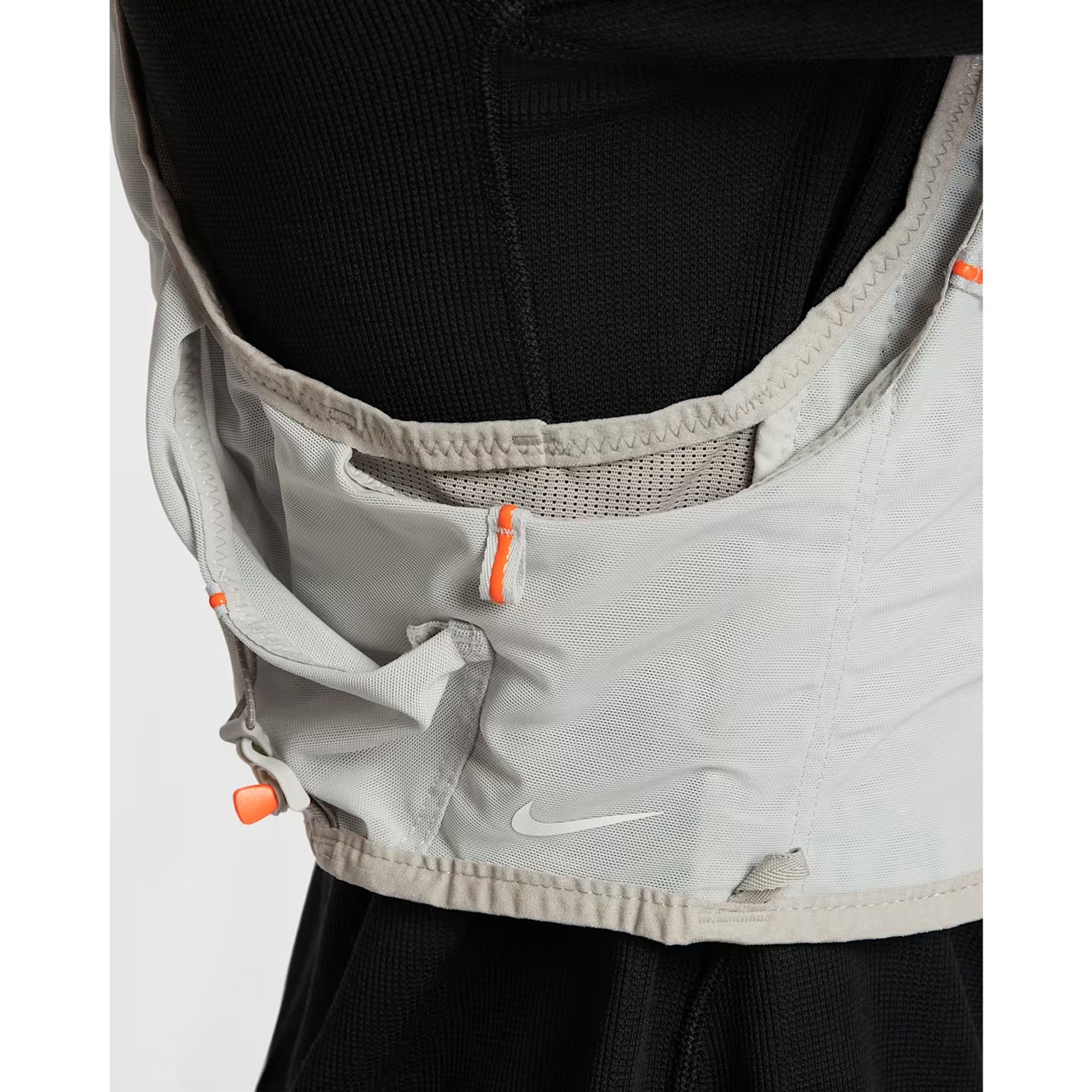 Nike ACG Goat Pack 5L Vest in Grey Fog / Safety Orange / Summit White — closeup showing side flex carry adaptable storage, DotAir body fabric stretch and grey fog DyneemaⓇ mesh base with summit white piping detail