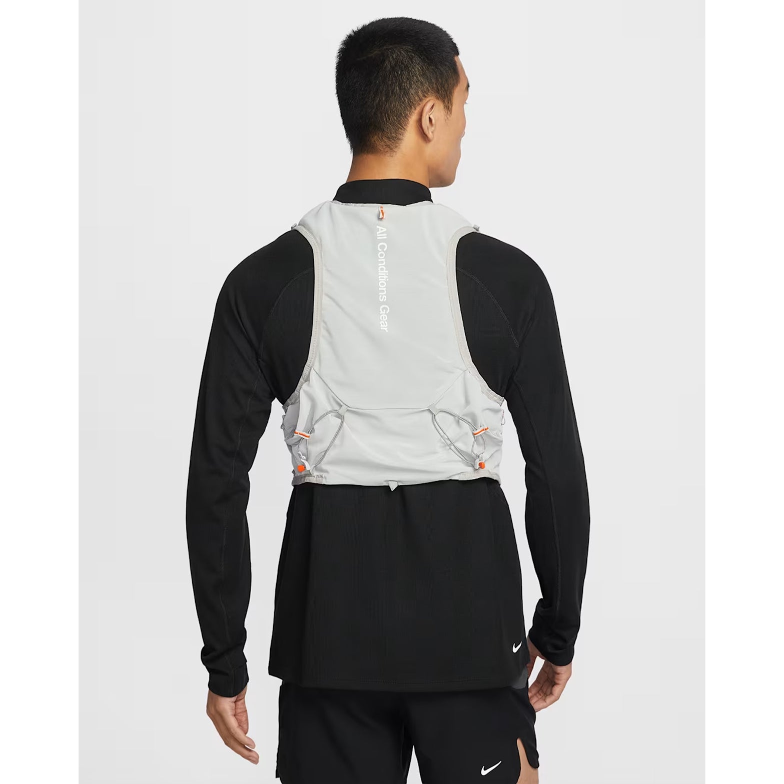 Nike ACG Goat Pack 5L Vest in Grey Fog / Safety Orange / Summit White — back product shot showing rear hydration carry, integrated ice tool carry with axle toggle, summit white accent and grey fog DyneemaⓇ mesh construction