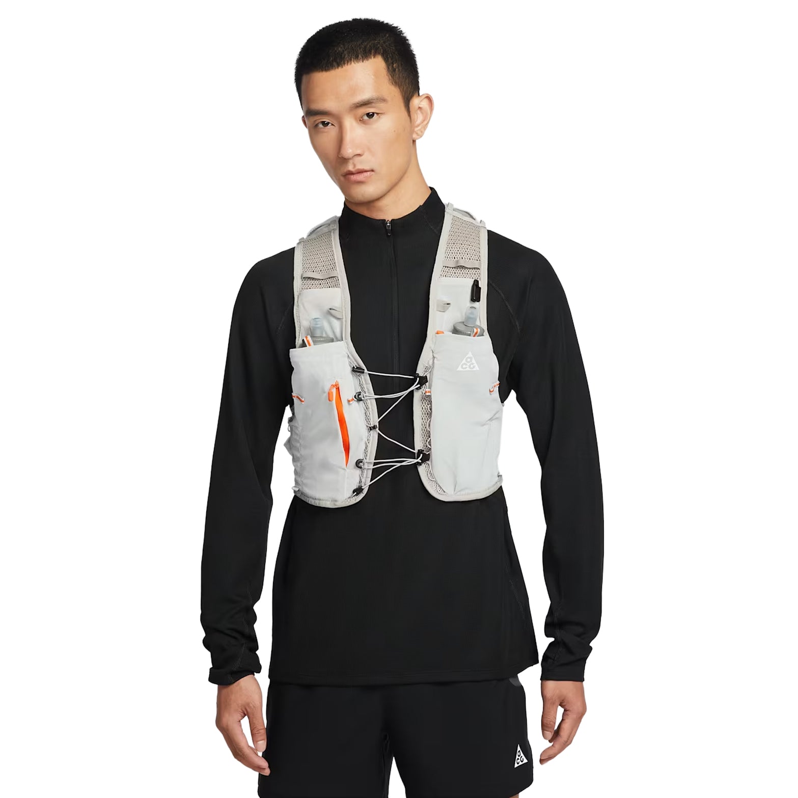 Nike ACG Goat Pack 5L Vest in Grey Fog / Safety Orange / Summit White — front view worn on model showing grey fog DyneemaⓇ mesh base, safety orange detailing, chest tension system and integrated pole quiver