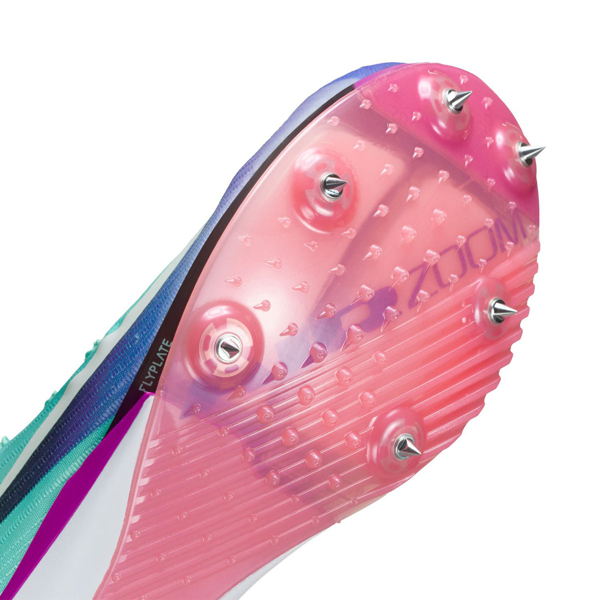 Close-up of the pink outsole of a track spike shoe showing metal spikes and textured grip pattern, designed for running on track surfaces.