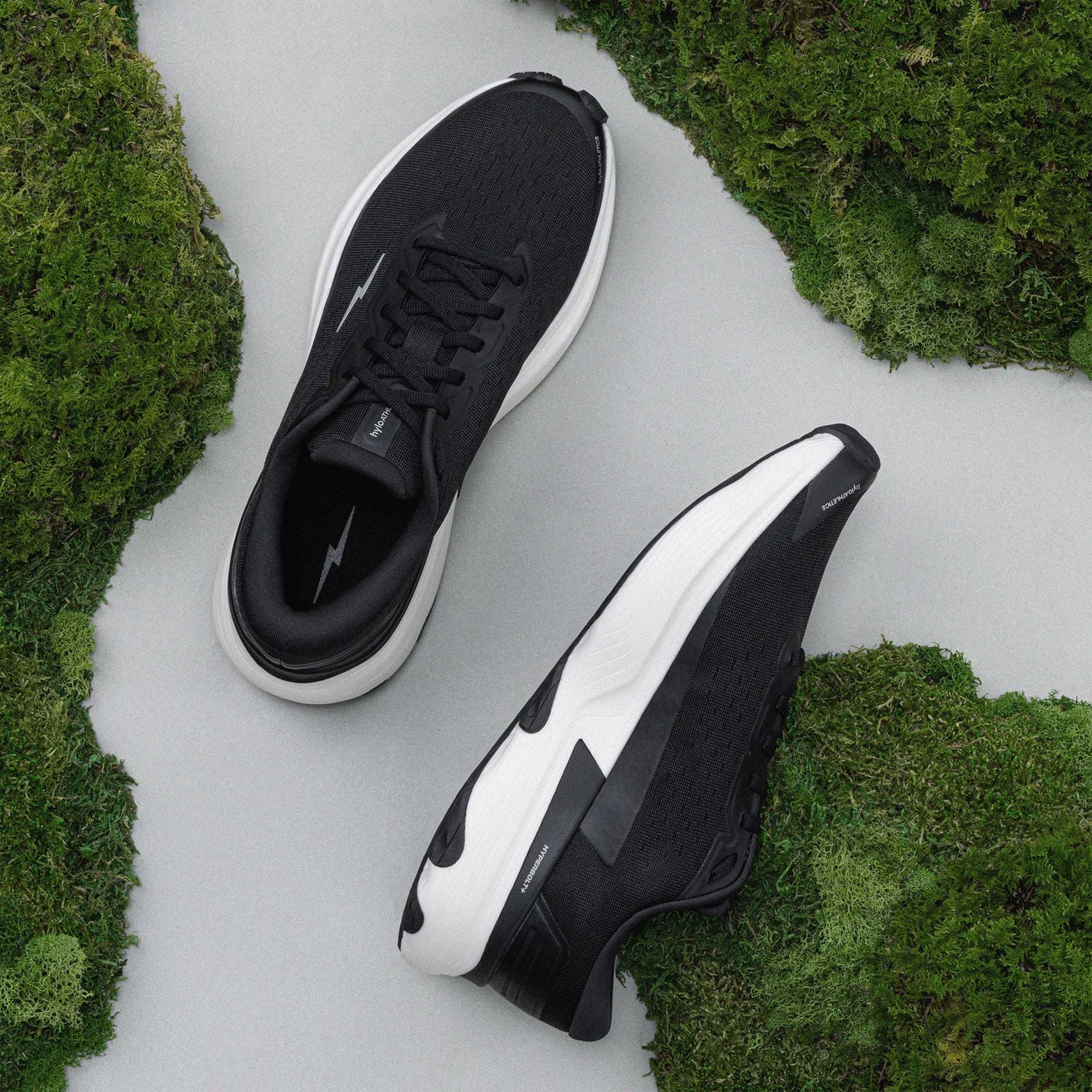 Hylo AXIS Running Shoes Black Undyed showing top view of engineered Jacquard warp knit upper and inner side view displaying bio-based cushioning with lightweight stability