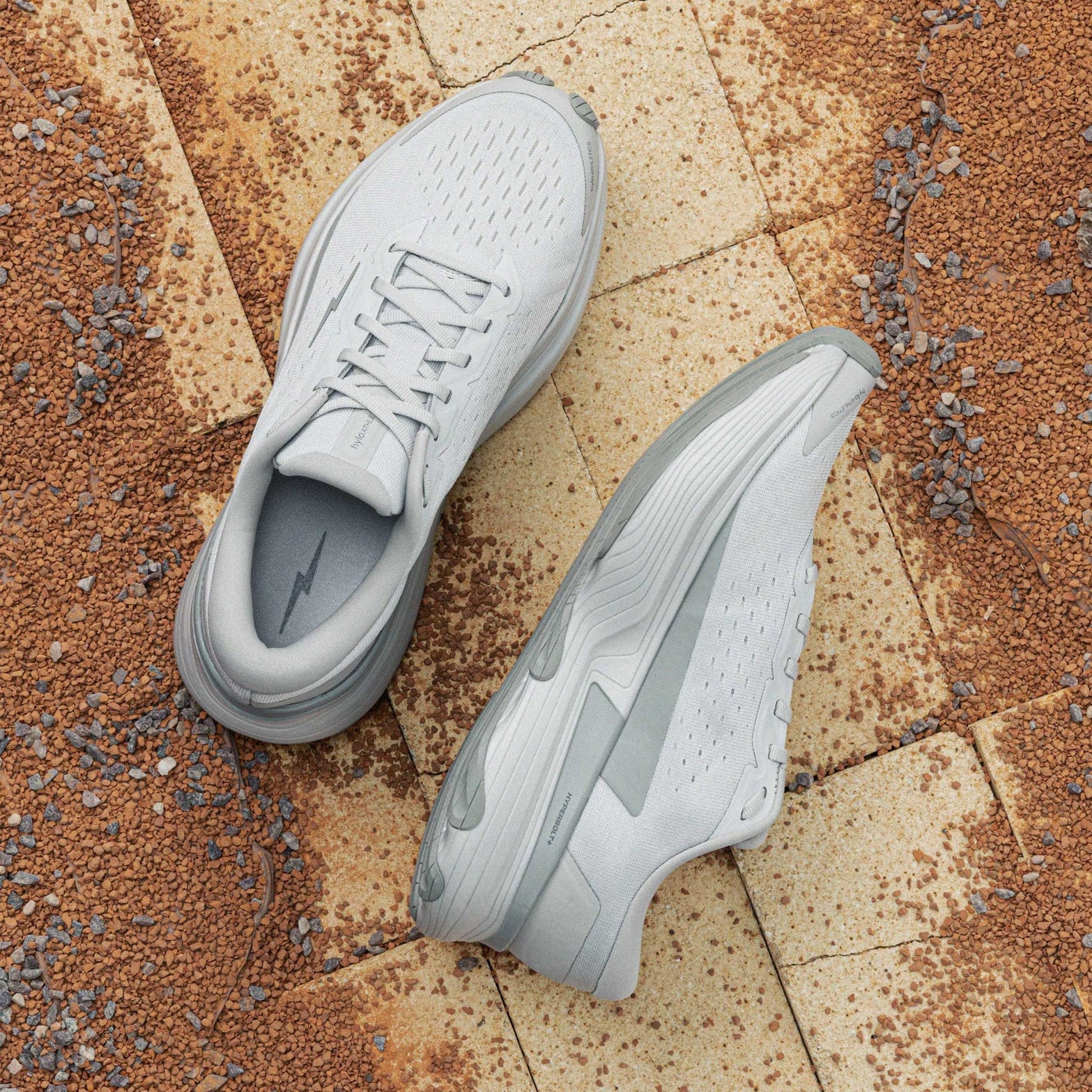 Hylo AXIS Running Shoes Grey showing top view of engineered Jacquard warp knit upper and inner side view displaying bio-based cushioning with lightweight stability
