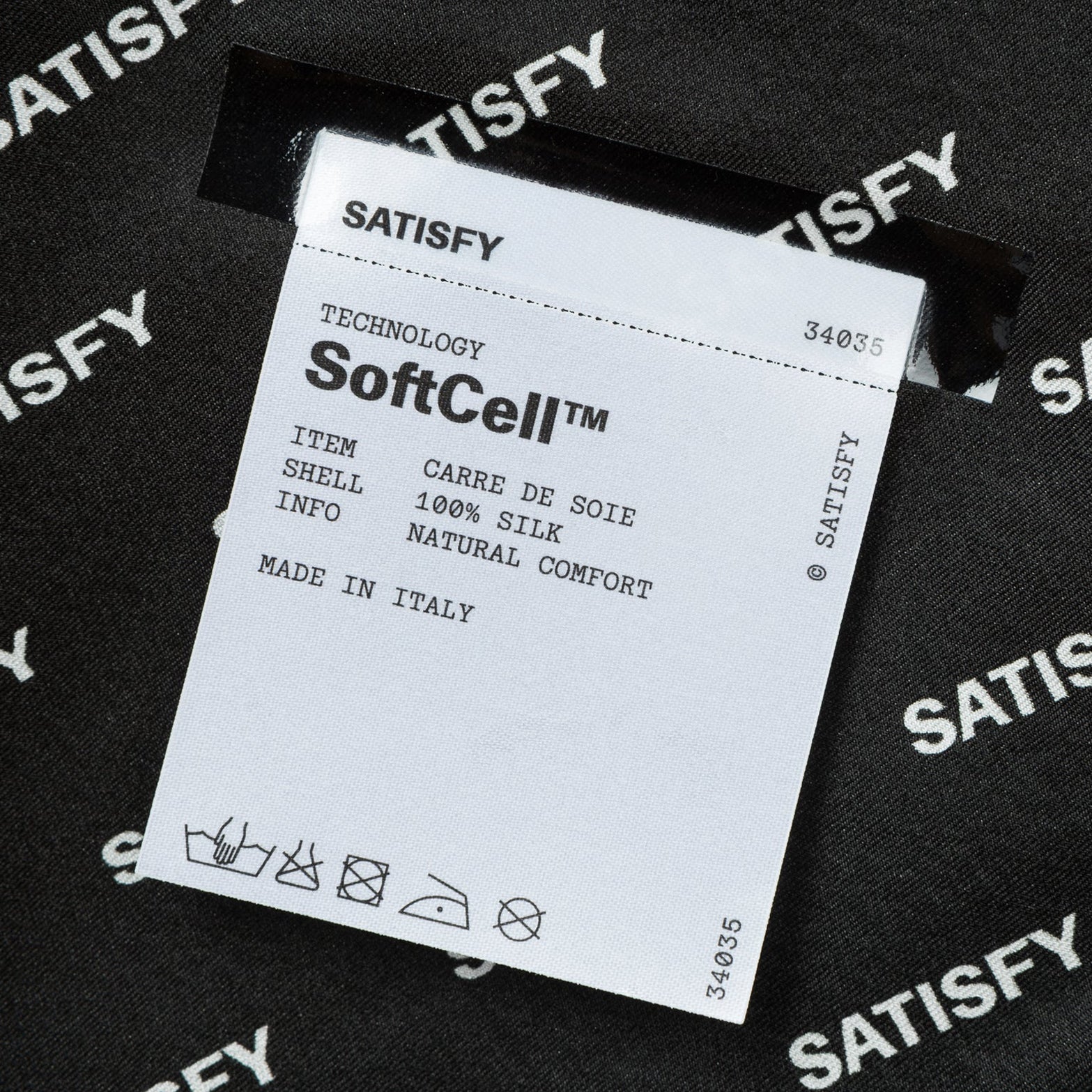 Satisfy Carré de Soie SoftCell™ Bandana in Jet Black — closeup showing fully detachable exterior care label on jet black SoftCell™ Italian silk construction