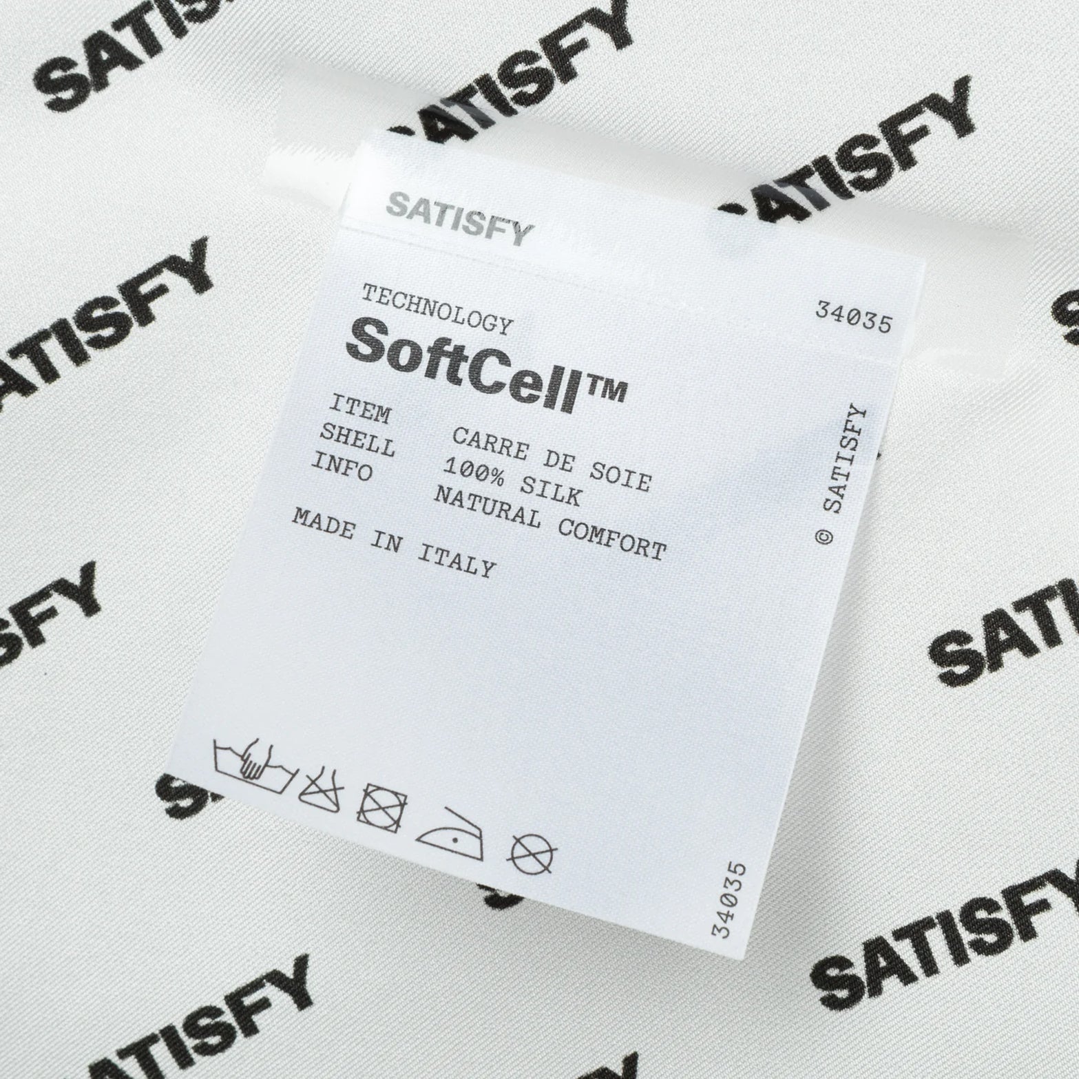 Satisfy Carré de Soie SoftCell™ Bandana in White Down — closeup showing fully detachable exterior care label on white down SoftCell™ Italian silk construction