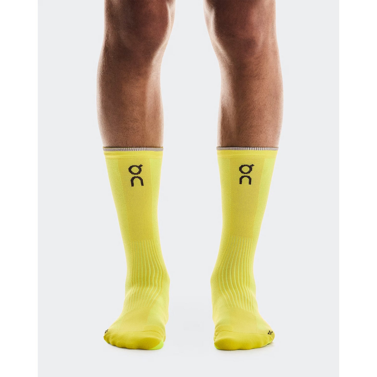 On Elite Run Sock High Lime front view on runner showing high-cut length with built-in arch support, ribbed instep and targeted compression zones