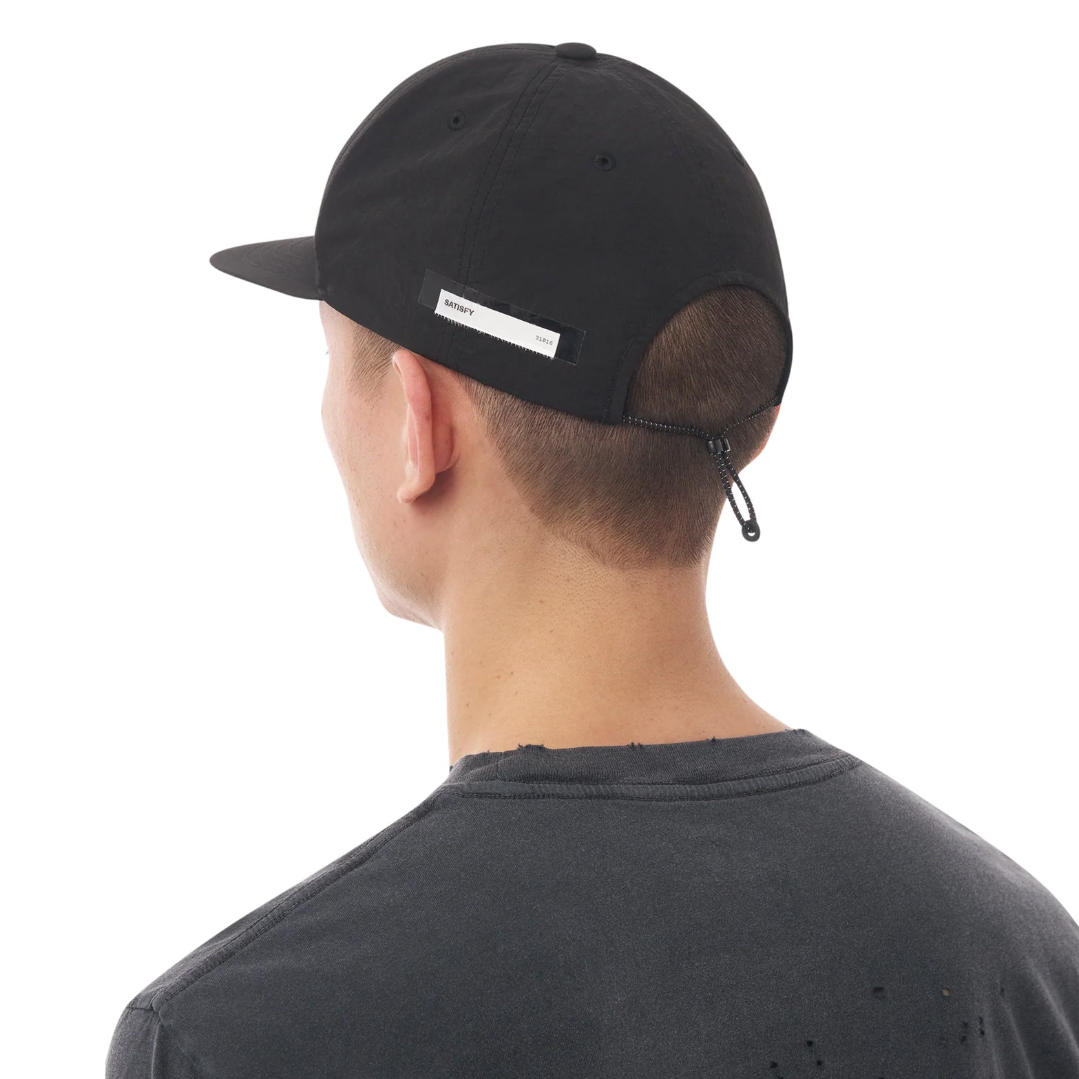 Satisfy FliteSilk™ 5 Panel Pinch Cap in Black Eagle — back view worn on model showing adjustable bungee cord toggle closure and black FliteSilk™ Italian nylon construction