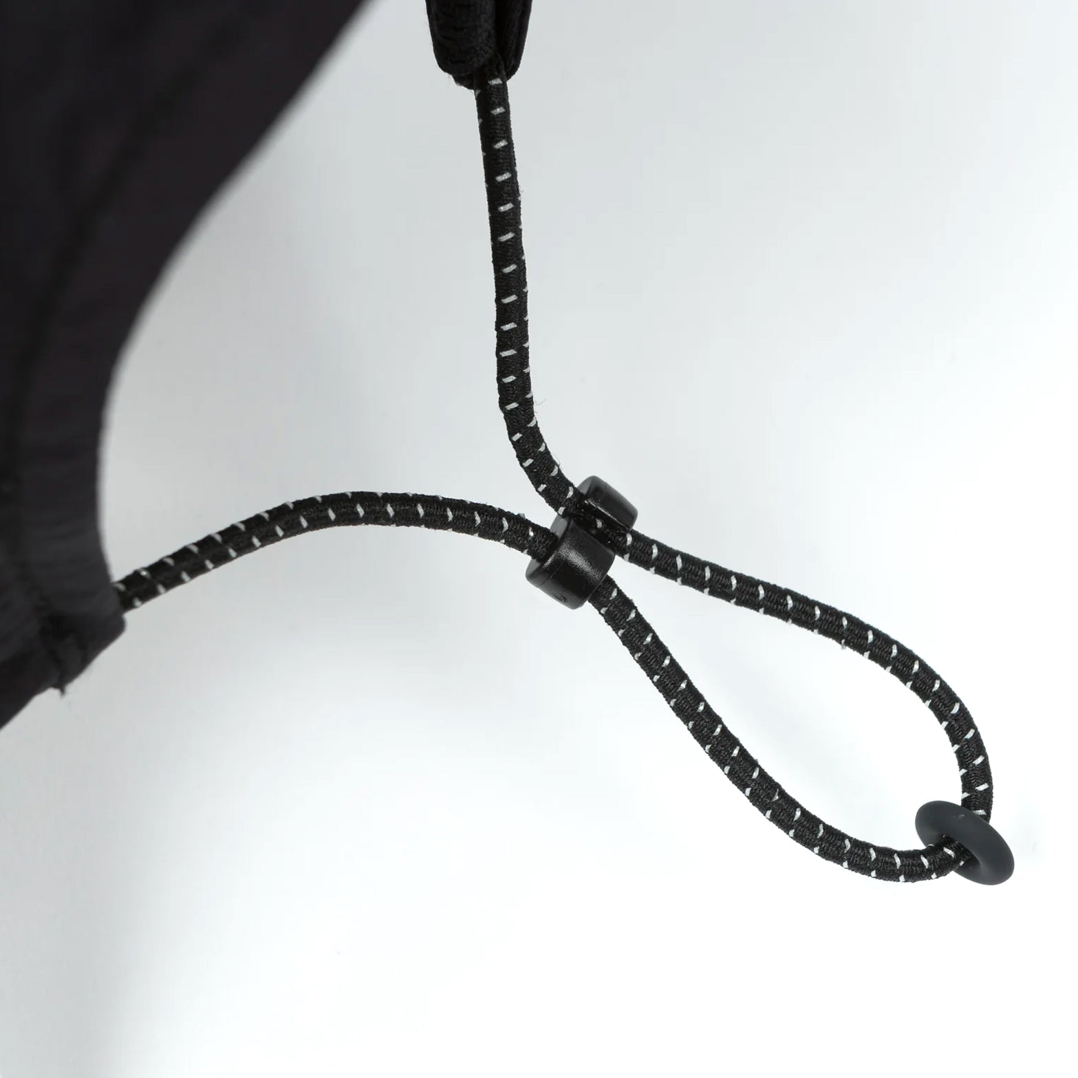 Satisfy FliteSilk™ 5 Panel Pinch Cap in Black Eagle — closeup showing adjustable bungee cord system and toggle closure detail on black FliteSilk™ nylon construction