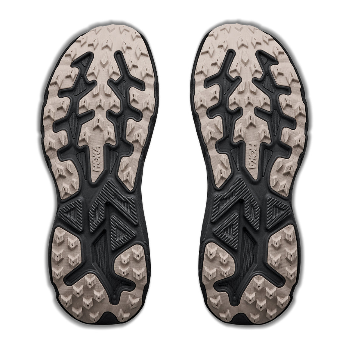 Two beige and black outsoles from Men’s Challenger 8 GORE-TEX Trail Running Shoes Antique Olive / Black by Hoka, with rugged treads for grip, are displayed side by side on a white background.