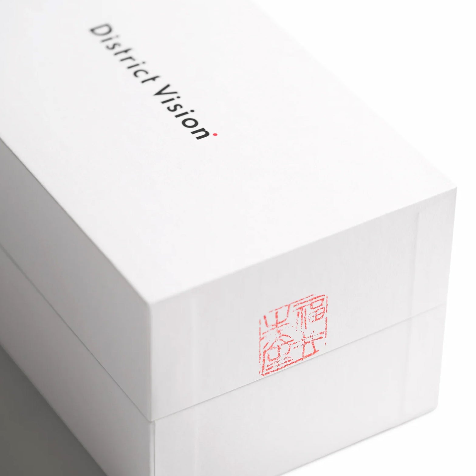 District Vision Koharu Eclipse in Desert Rose D+ Aqua Mirror — closeup showing District Vision branded packaging detail and desert rose frame and D+ Aqua Mirror lens presentation