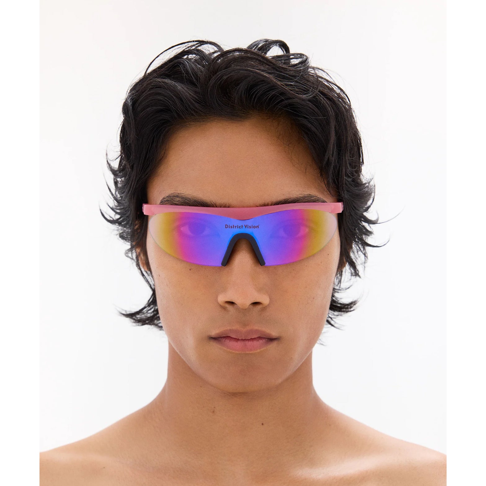 District Vision Koharu Eclipse in Desert Rose D+ Aqua Mirror — worn on male model showing six-base frame fit, desert rose colourway and D+ Aqua Mirror lens in natural light