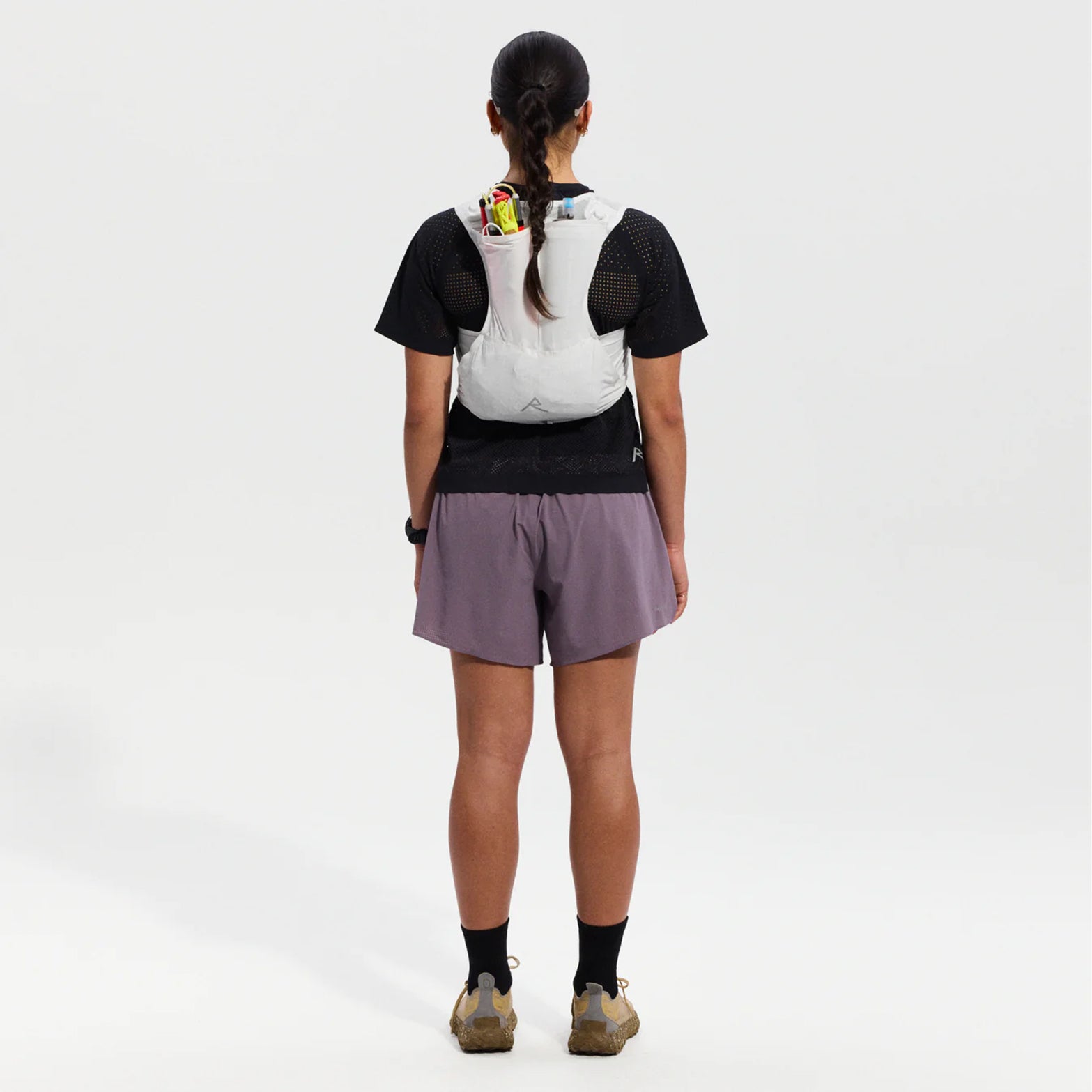 Raide LF 5L Running Vest in White — full body back view worn on model showing rear hydration carry, integrated ice tool carry with axle toggle and rear passthrough pocket construction