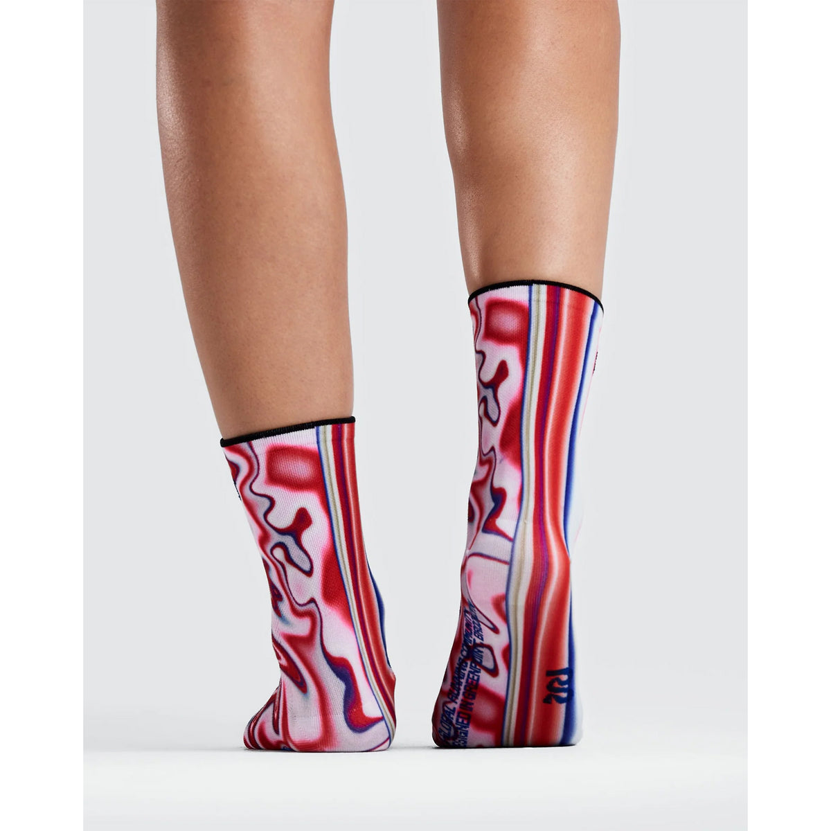 A person wearing Bandit Lite Run 2 Pack Quarter Socks featuring a red, white, and blue melted-stripe gradient pattern.