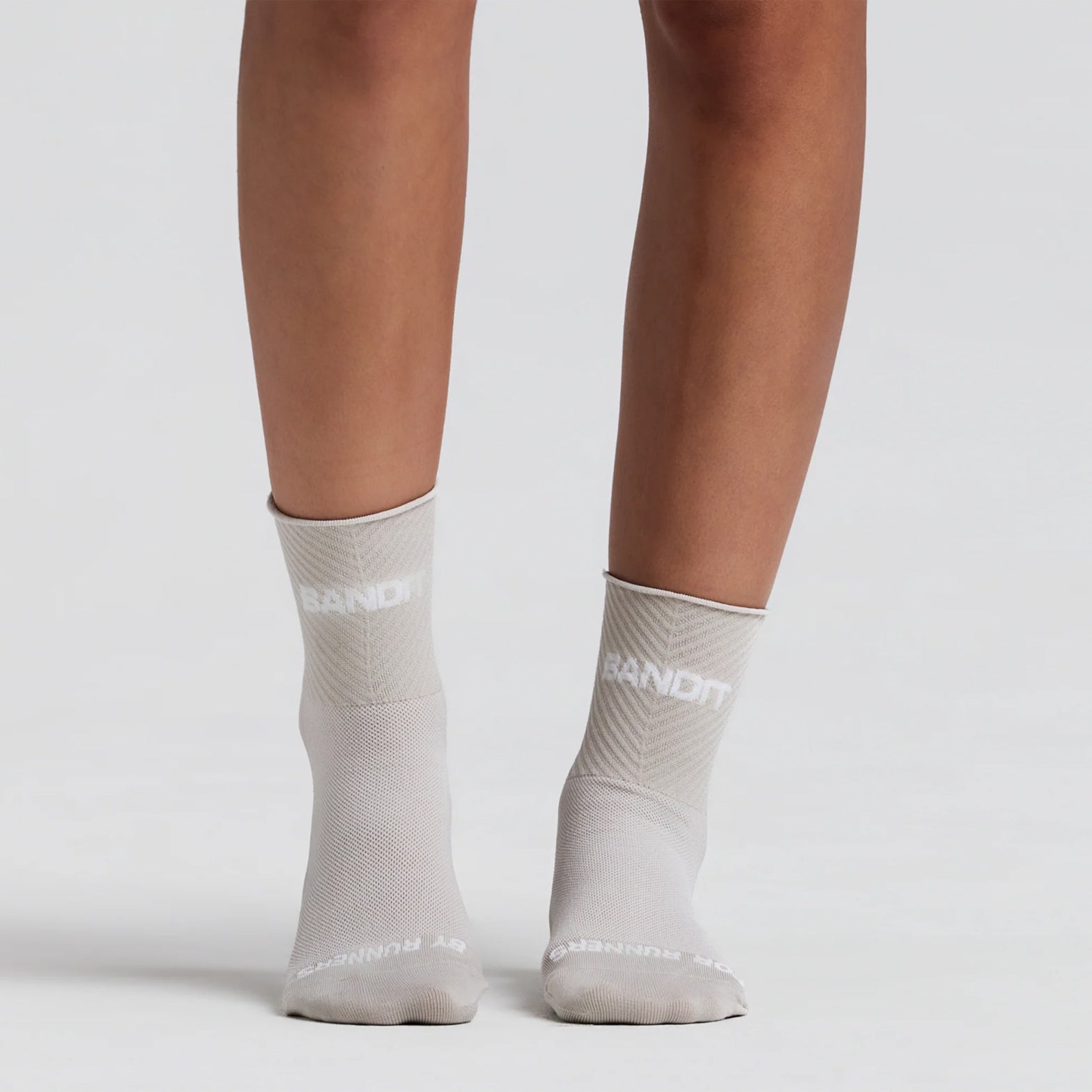 Bandit Lite Run 2 Pack Stripe Jacquard Socks Plaster on runner showing stripe jacquard construction with quarter-length cut and spandex compression for featherweight breathable running performance
