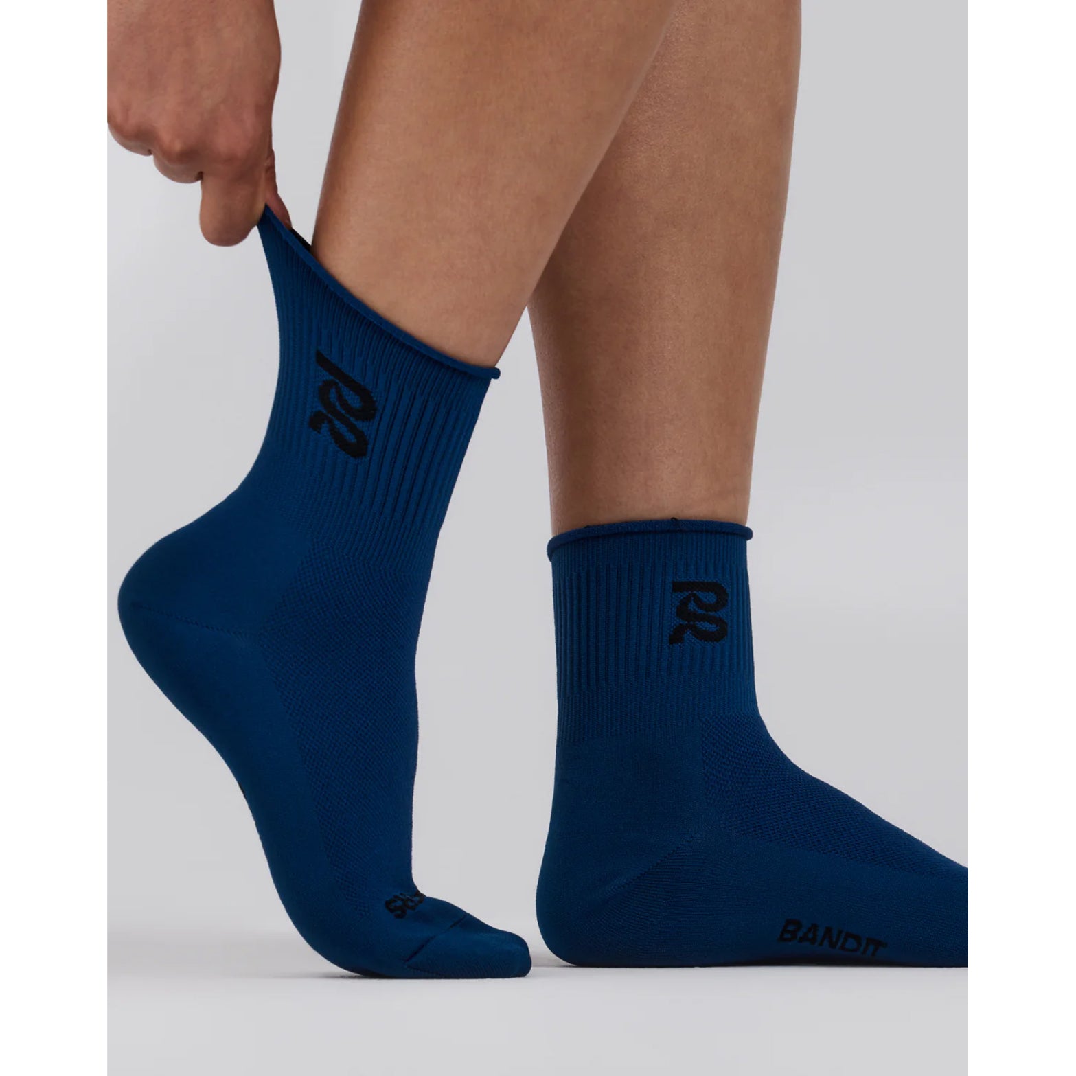 Bandit Lite Run Ribbed Quarter Socks Aegean close-up on runner showing featherweight feel with ribbed detail and knit branding at both sides of ankle