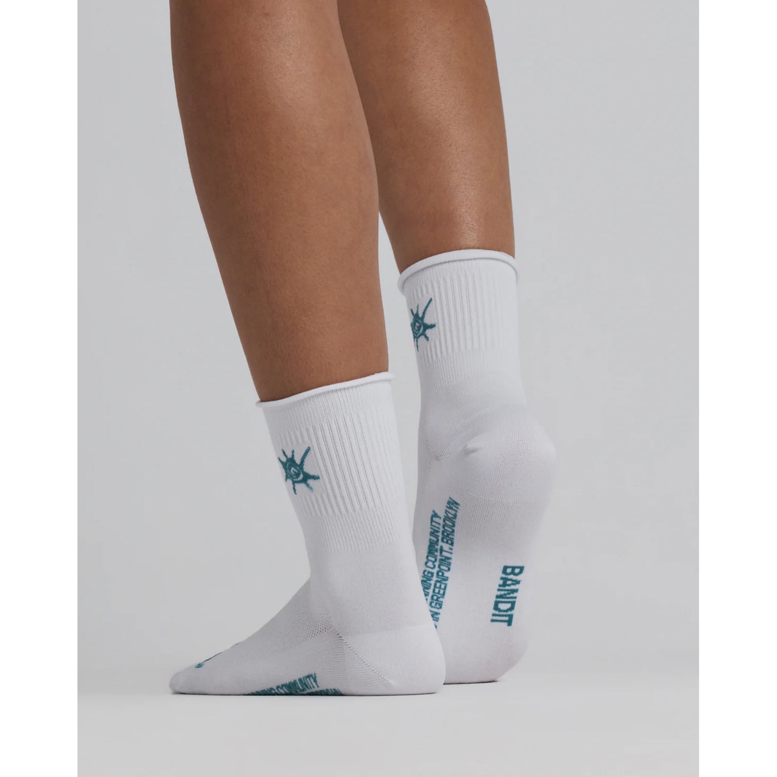Bandit Lite Run™ Ribbed Quarter Socks in White / Tranquil Blue — back view worn on model showing quarter-length cut, ribbed ankle detail and tranquil blue knit Bandit branding at heel
