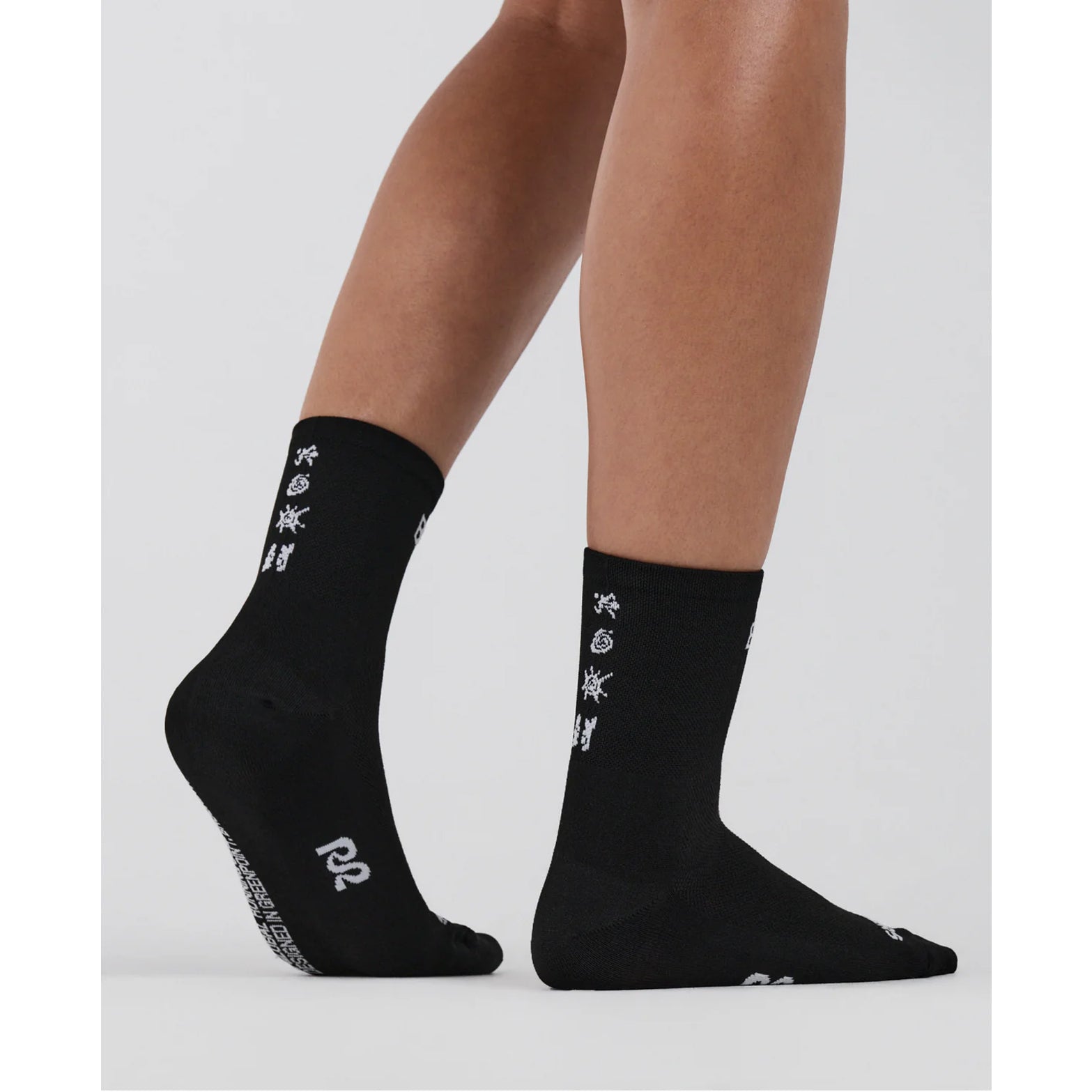 Bandit Lite Run Spring Motif Quarter Socks Black White close-up on runner showing featherweight feel with Bandit logo at front shaft and seasonal spring motif along back shaft