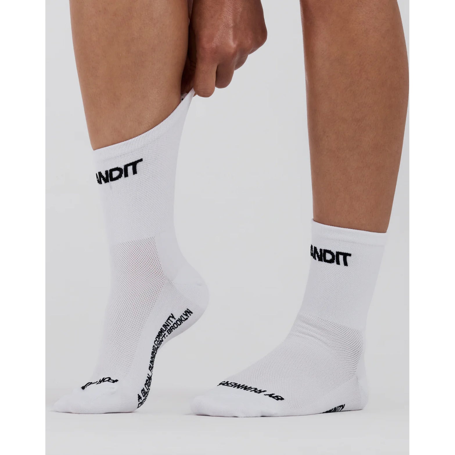 Bandit Lite Run Spring Motif Quarter Socks White Black close-up on runner showing featherweight feel with Bandit logo at front shaft and seasonal spring motif along back shaft