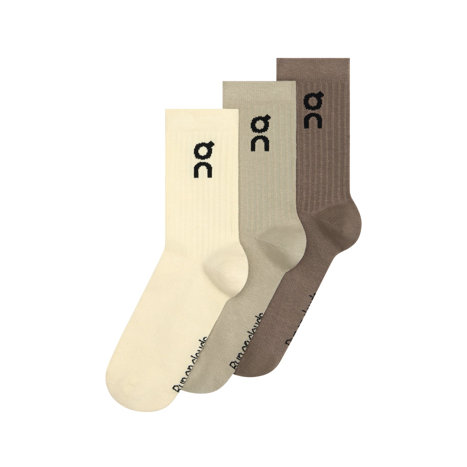 Three pairs of On Logo Socks High in Hare and Brume—a pack featuring cream, light beige, and brown shades—are displayed side by side. Each sock has a distinctive black “oc” logo near the top and branding near the toe. Designed as versatile running socks, they deliver all-day comfort and gentle arch support for whatever your day holds.