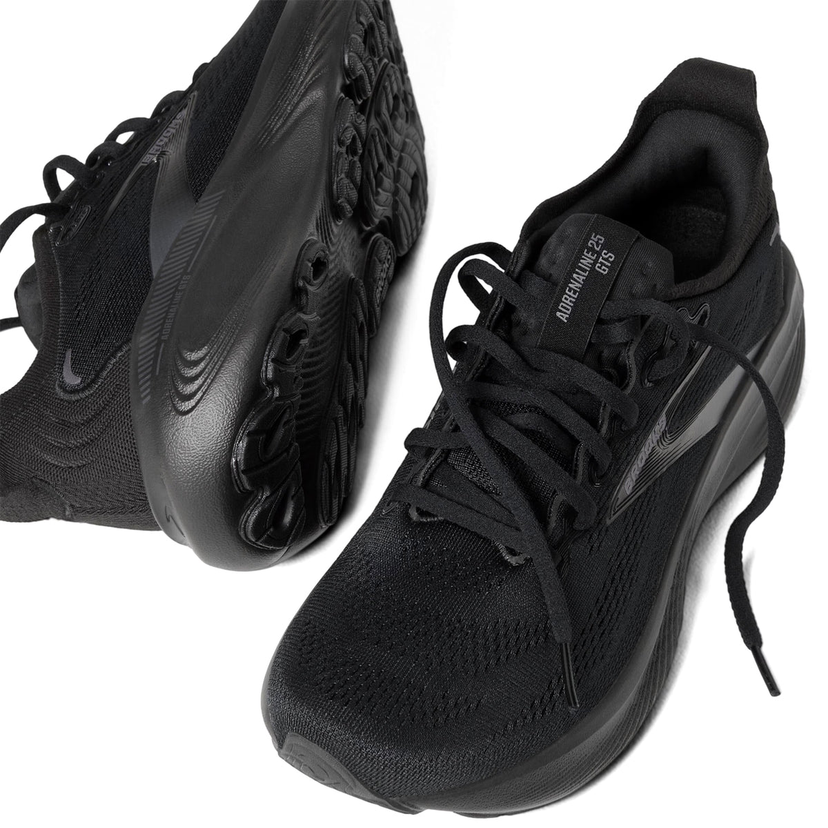 A pair of black Nike running shoes, shown from above and the side. One shoe displays the sole, while the other shows the laces and Air Zoom EG5 label on the tongue.