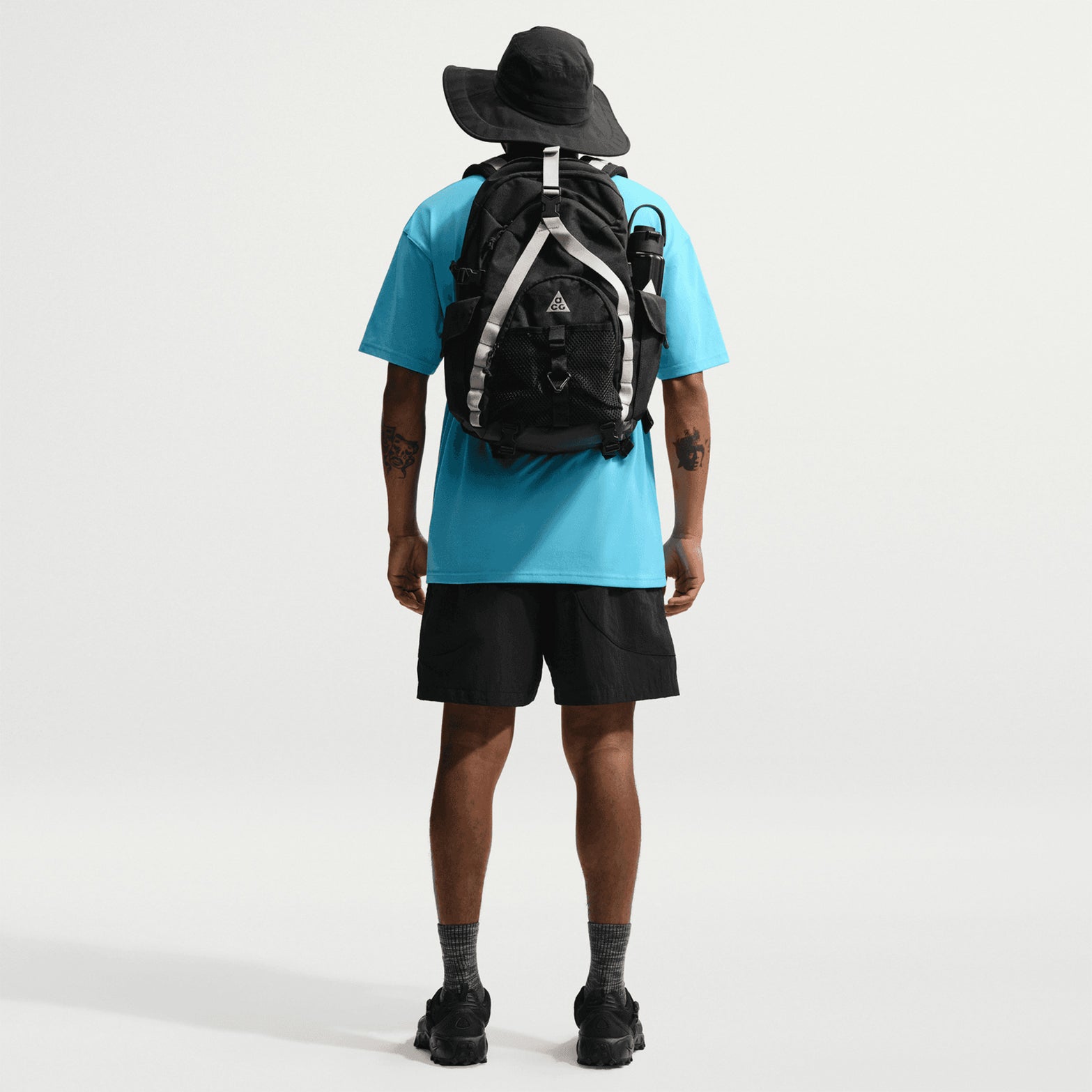 Men's Nike ACG Dolomiti Shorts Black Summit White full body back view on male model showing snap closure back pocket and woven Dolomiti label