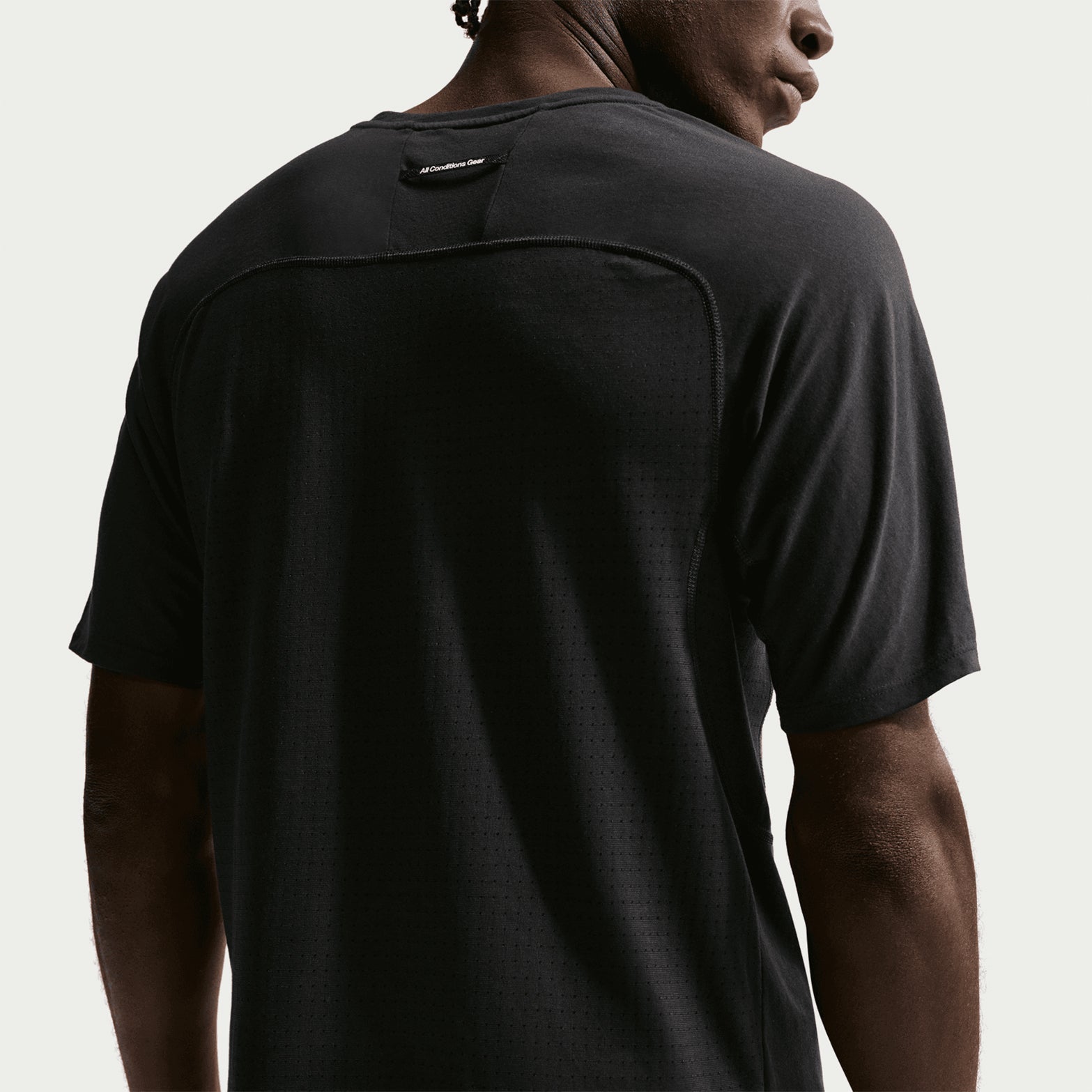 Men's Nike ACG Solar Chase Dri-FIT ADV Trail Running Tee Black Summit White back view showing strategic mesh panels at back and armpits for targeted breathability during trail running