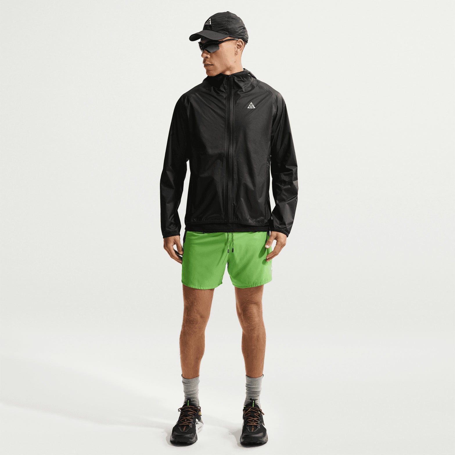 Nike ACG Trailwind men's Storm-FIT ADV jacket in Anthracite / Summit White — full body front view worn on model showing anthracite Storm-FIT ADV waterproof construction and summit white detailing with elastic cuffs
