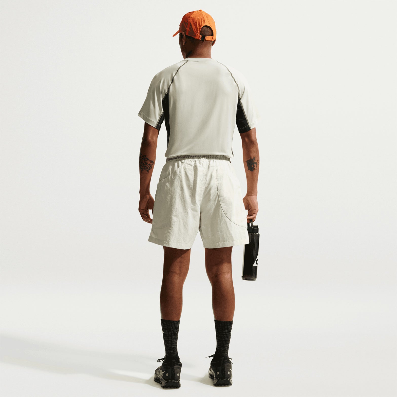 Men's Nike ACG Wildsee Dri-FIT Base-Layer Tee Sea Glass Black Spruce Summit White full body back view on male model showing UV-resistant construction with Dri-FIT moisture-wicking and ACG nesting system design for mountain running and layering