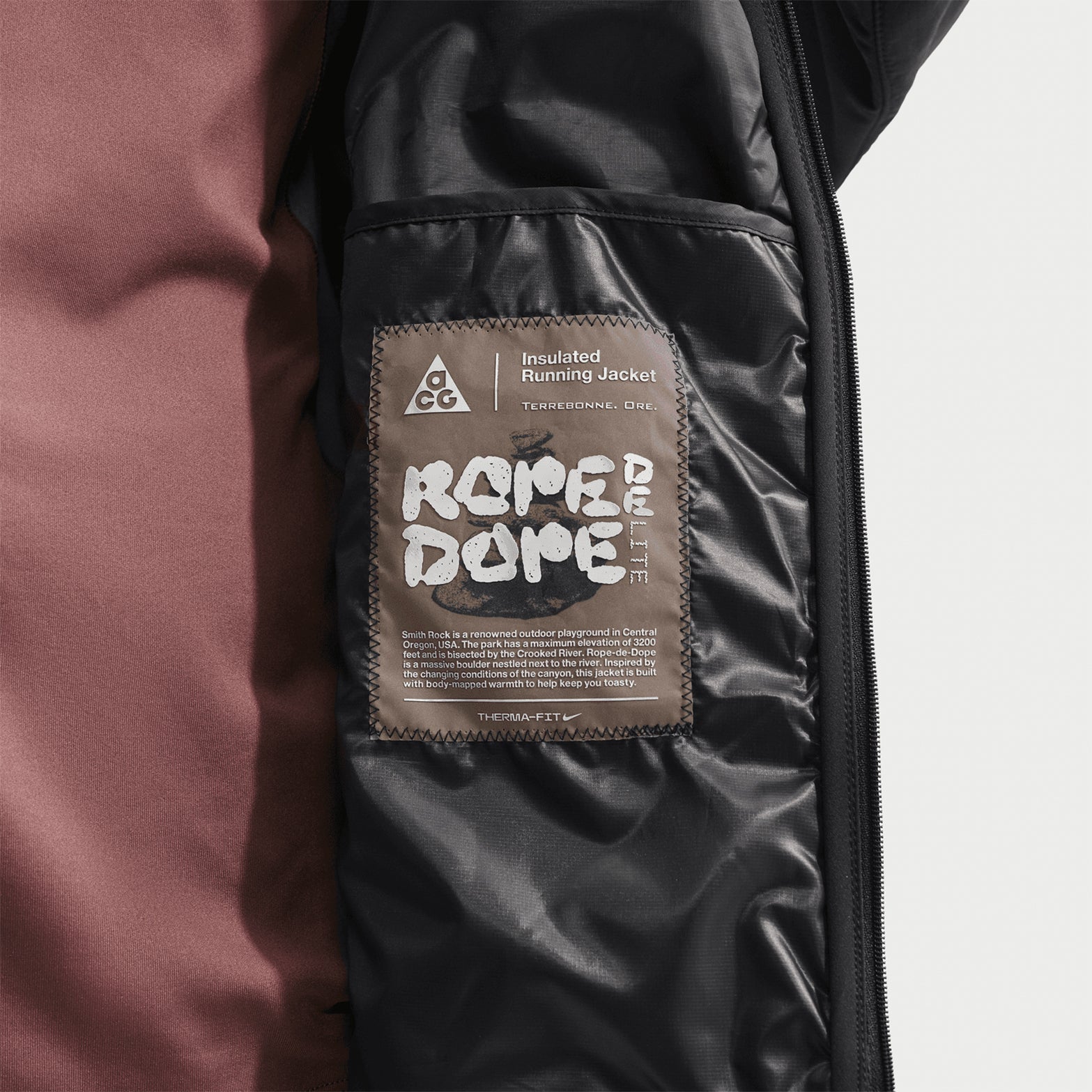 Men's Nike ACG Rope de Dope Jacket Black Summit White close-up of internal product label showing Therma-FIT ADV and Primaloft insulation specifications with ACG construction details