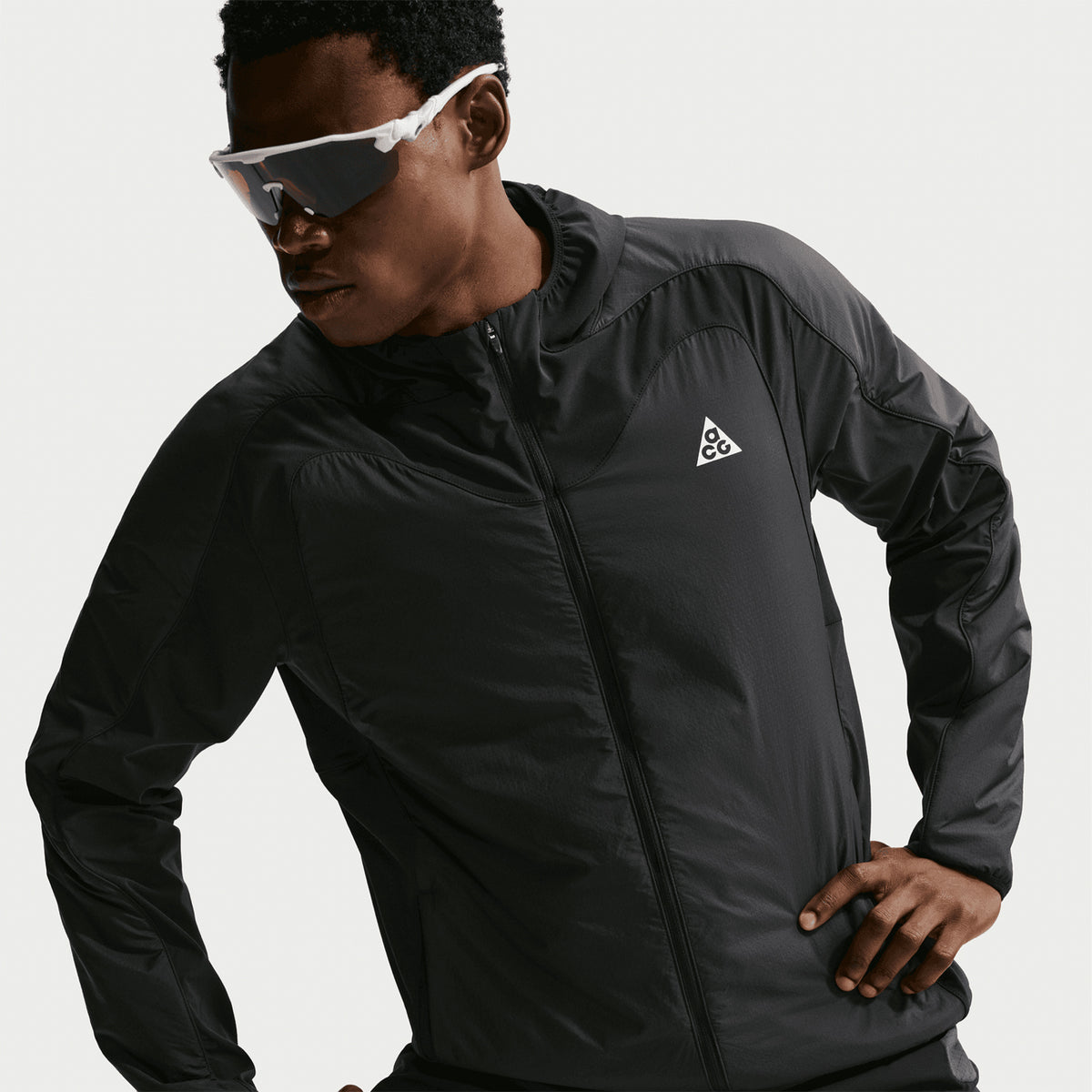 Men's Nike ACG Rope de Dope Jacket Black Summit White closer front view on male runner showing Therma-FIT ADV heat-regulating construction with Primaloft insulation, ripstop fabric and multiple pockets for cold weather trail running and outdoor activities