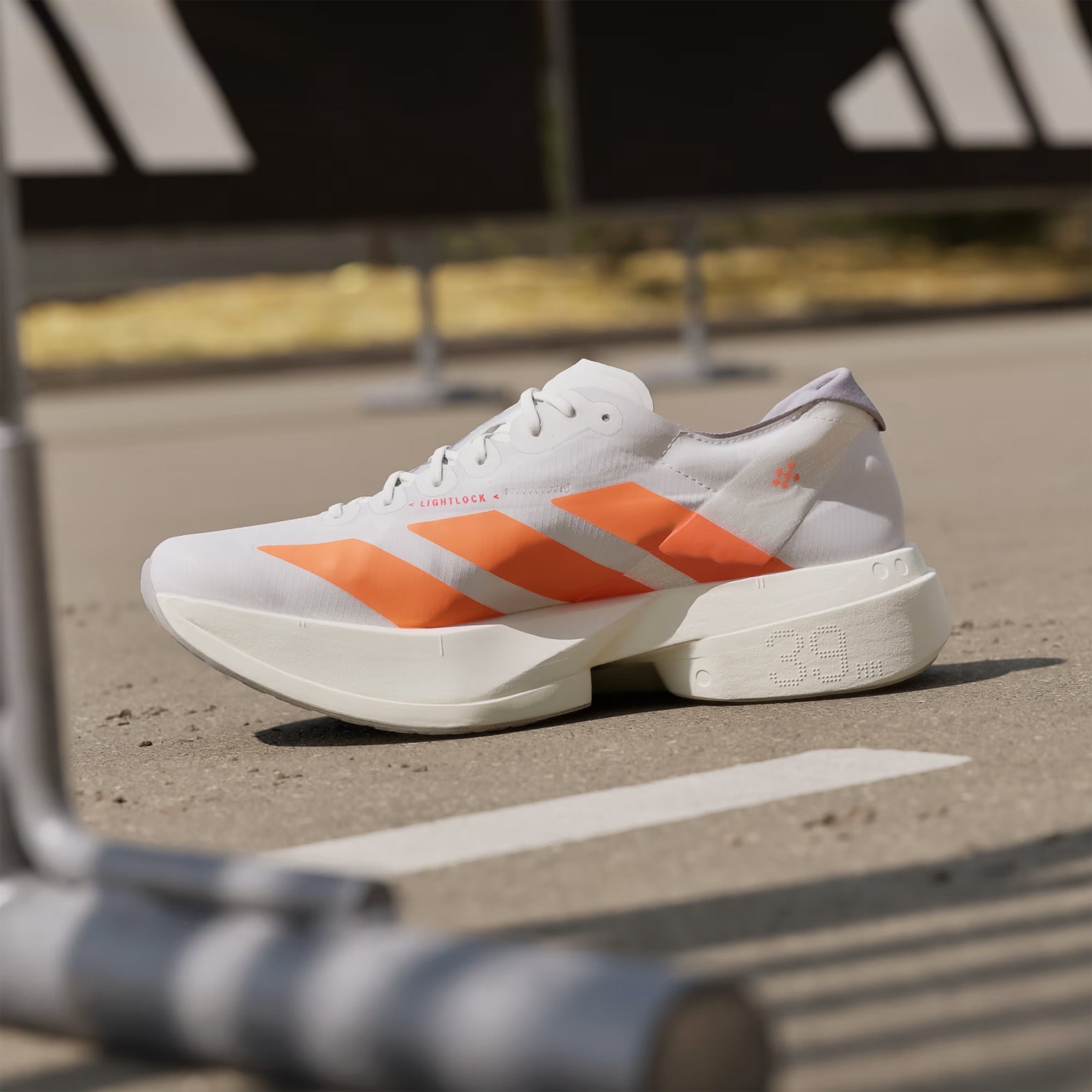 Adidas Adizero Adios Pro 4 Cloud White Lucid Orange Lucid Red inner side view featuring carbon-infused technology and rocker point midsol