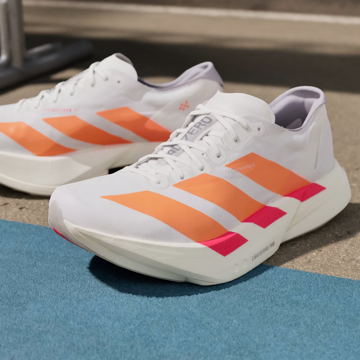 Adidas Adizero Adios Pro 4 men's running shoes Cloud White Lucid Orange Lucid Red side view pair showing racing geometry and lightweight design