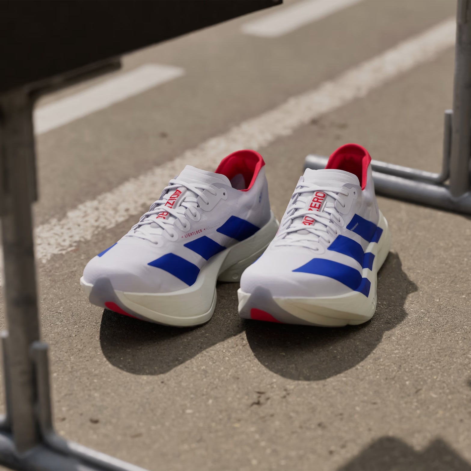 Men's adidas Adizero Adios Pro 4 Running Shoes White Blue Red angled top view showing lightweight racing upper and carbon plate racing construction