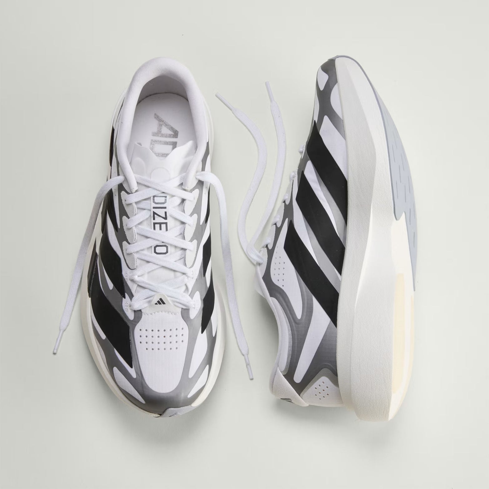 adidas Adizero EVO SL EXO men's running shoe in Cloud White / Core Black / Iron Metallic — top & inner view showing cloud white woven shell upper, exoskeleton heel-to-toe support structure, iron metallic midsole detailing and sculpted rubber outsole