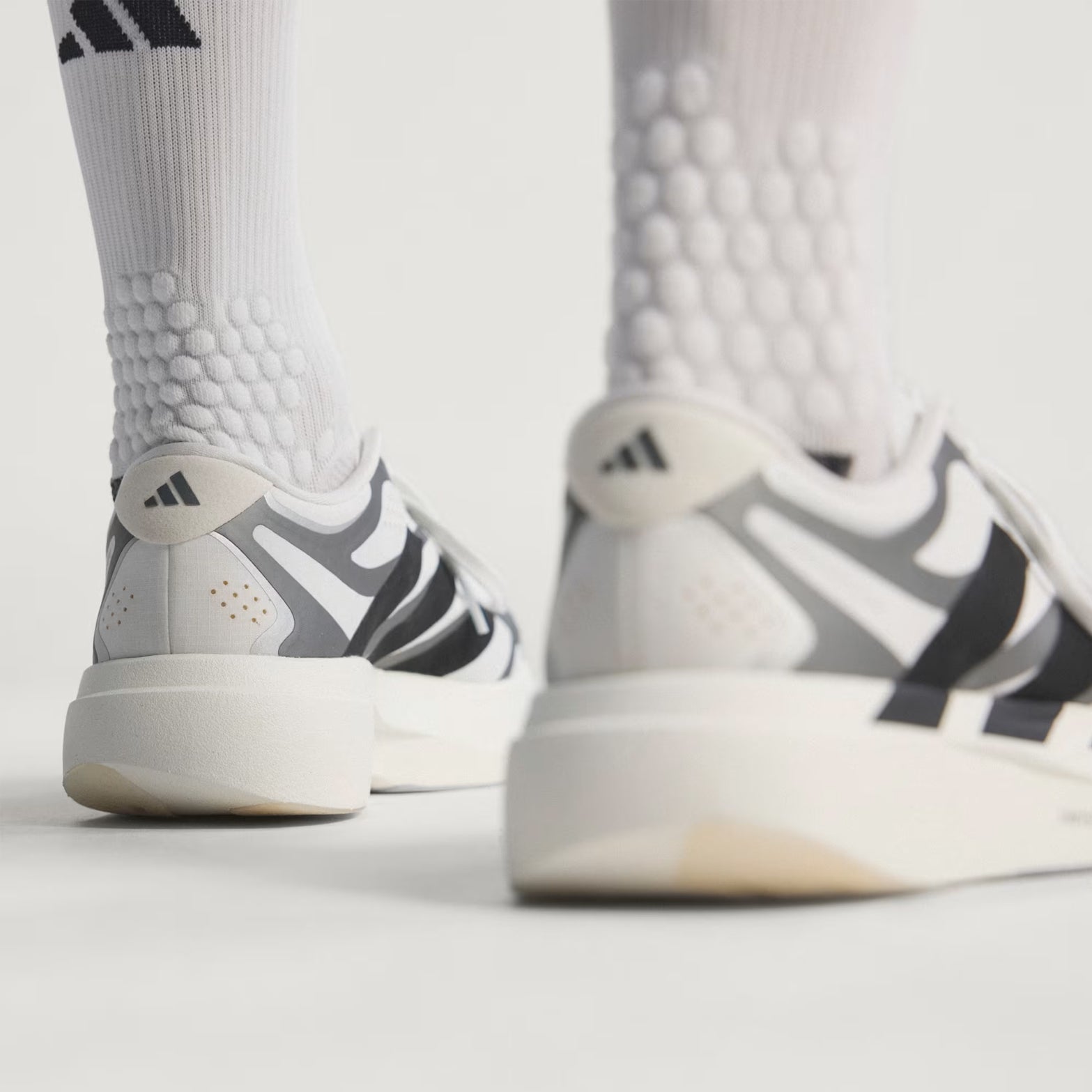 adidas Adizero EVO SL EXO men's running shoe in Cloud White / Core Black / Iron Metallic — heel view showing exoskeleton heel construction, core black detailing and iron metallic LightstrikePro midsole contrast