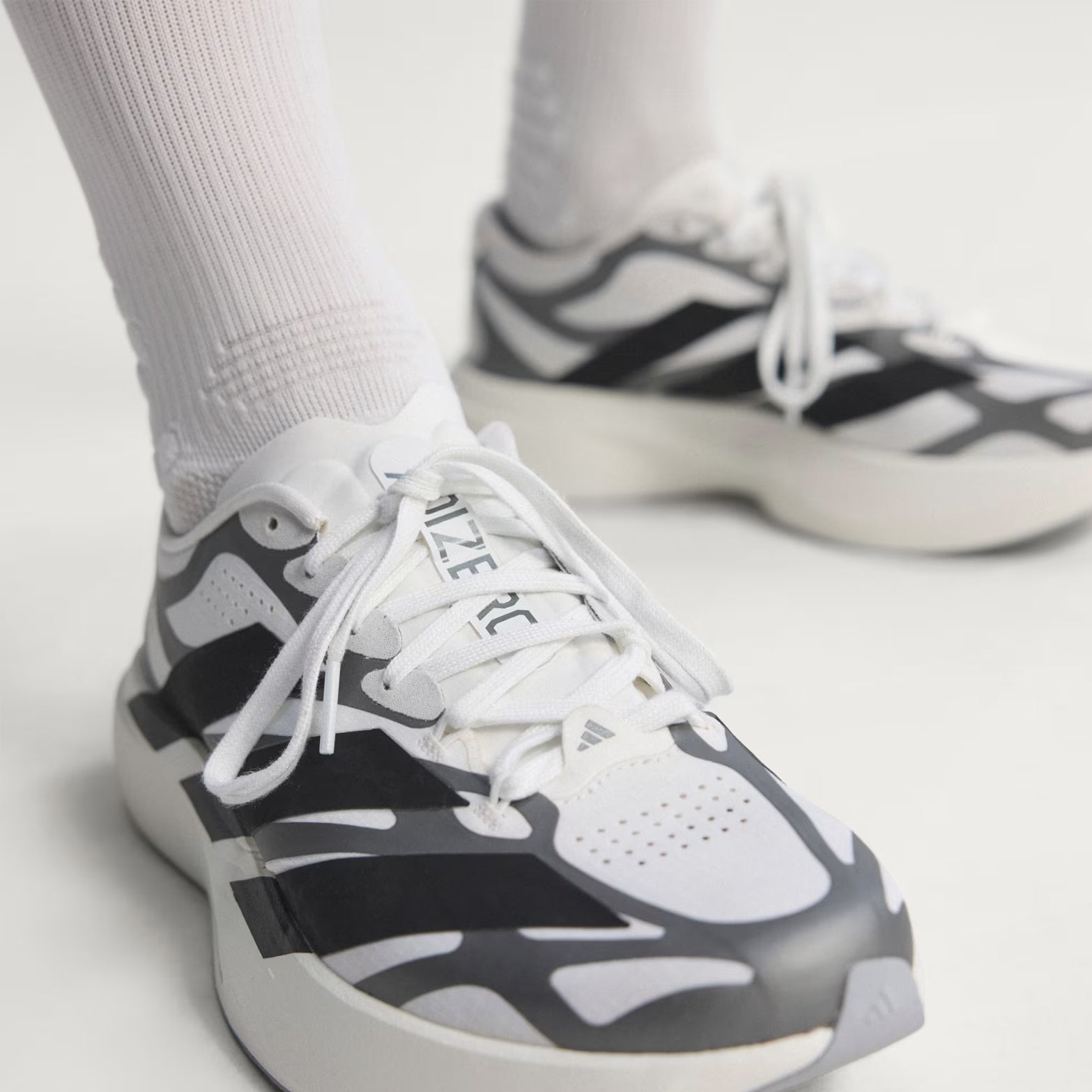 adidas Adizero EVO SL EXO men's running shoe in Cloud White / Core Black / Iron Metallic — top-down view showing cloud white woven shell upper, exoskeleton overlay system, lace closure and core black accent detailing