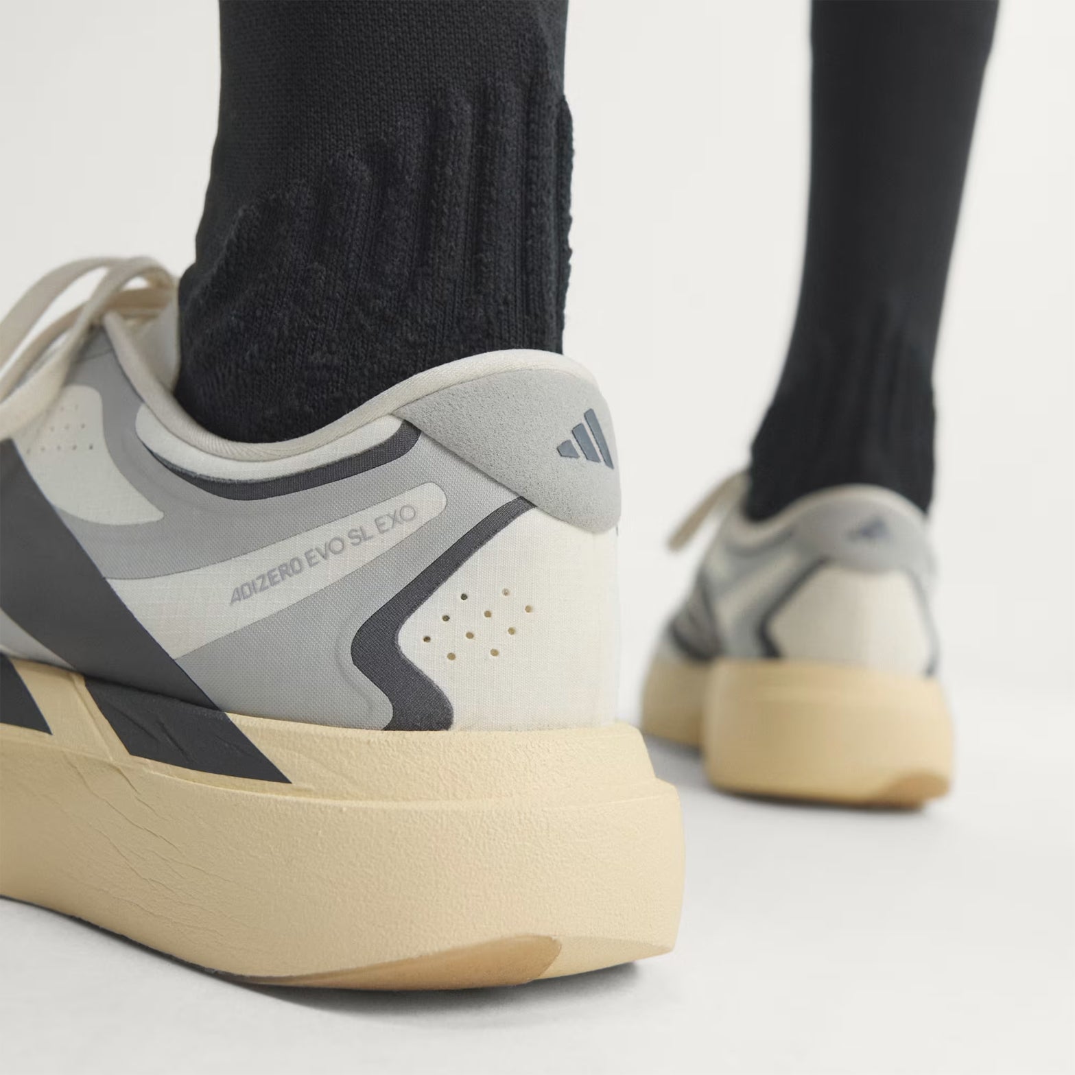 Men's adidas Adizero EVO SL EXO Running Shoes Core White Utility Black Grey Two heel view showing EXOSKELETON fit system with heel-to-toe support and LIGHTSTRIKE PRO energy return