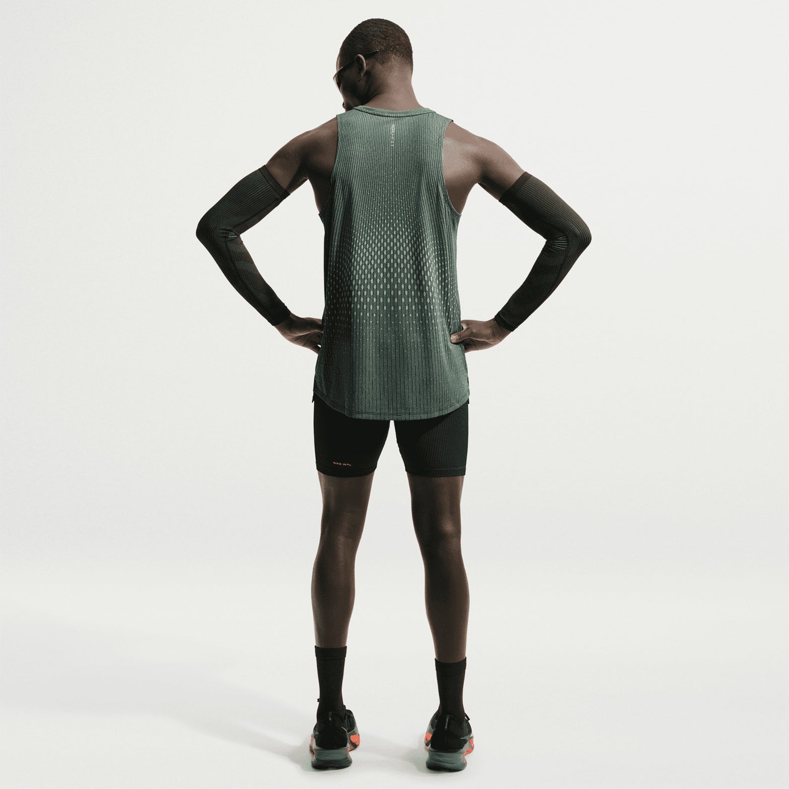 Men's Nike Aero-FIT Running Vest Black Light Green Spark Reflective Silver back full body view on male runner showing Aero-FIT mesh zones with side hem vents for unrestricted movement and maximum airflow during running