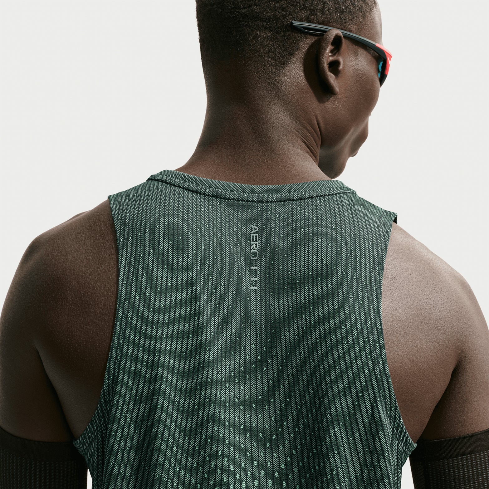 Men's Nike Aero-FIT Running Vest Black Light Green Spark Reflective Silver back view on male runner showing strategic mesh zones with Aero-FIT airflow construction and side hem vents for unrestricted movement"