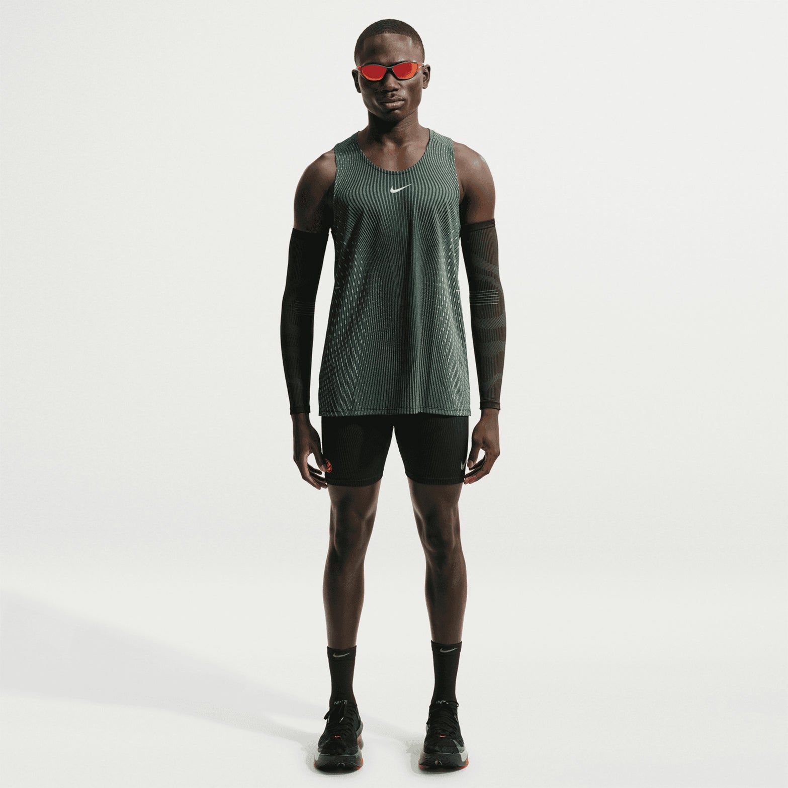 Men's Nike Aero-FIT Running Vest Black Light Green Spark Reflective Silver front full body view on male runner showing lightweight knit with Aero-FIT mesh zones for maximum breathability and cooling during running