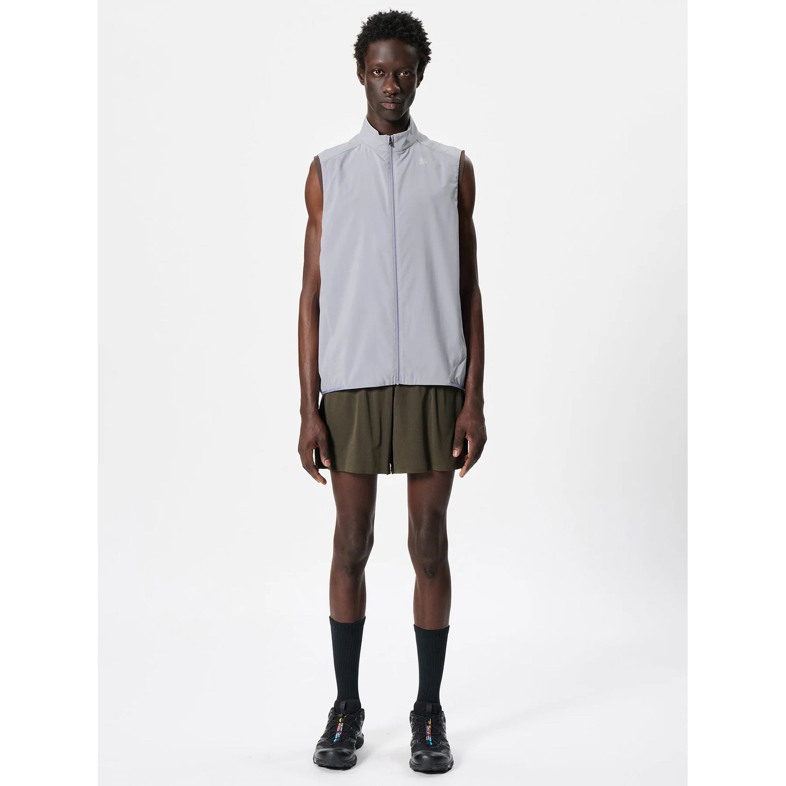 Goldwin Men's Air Pit Storage Shorts Jet Brown full body view on male runner showing breathable mesh outer shorts with built-in compression tights for summer training